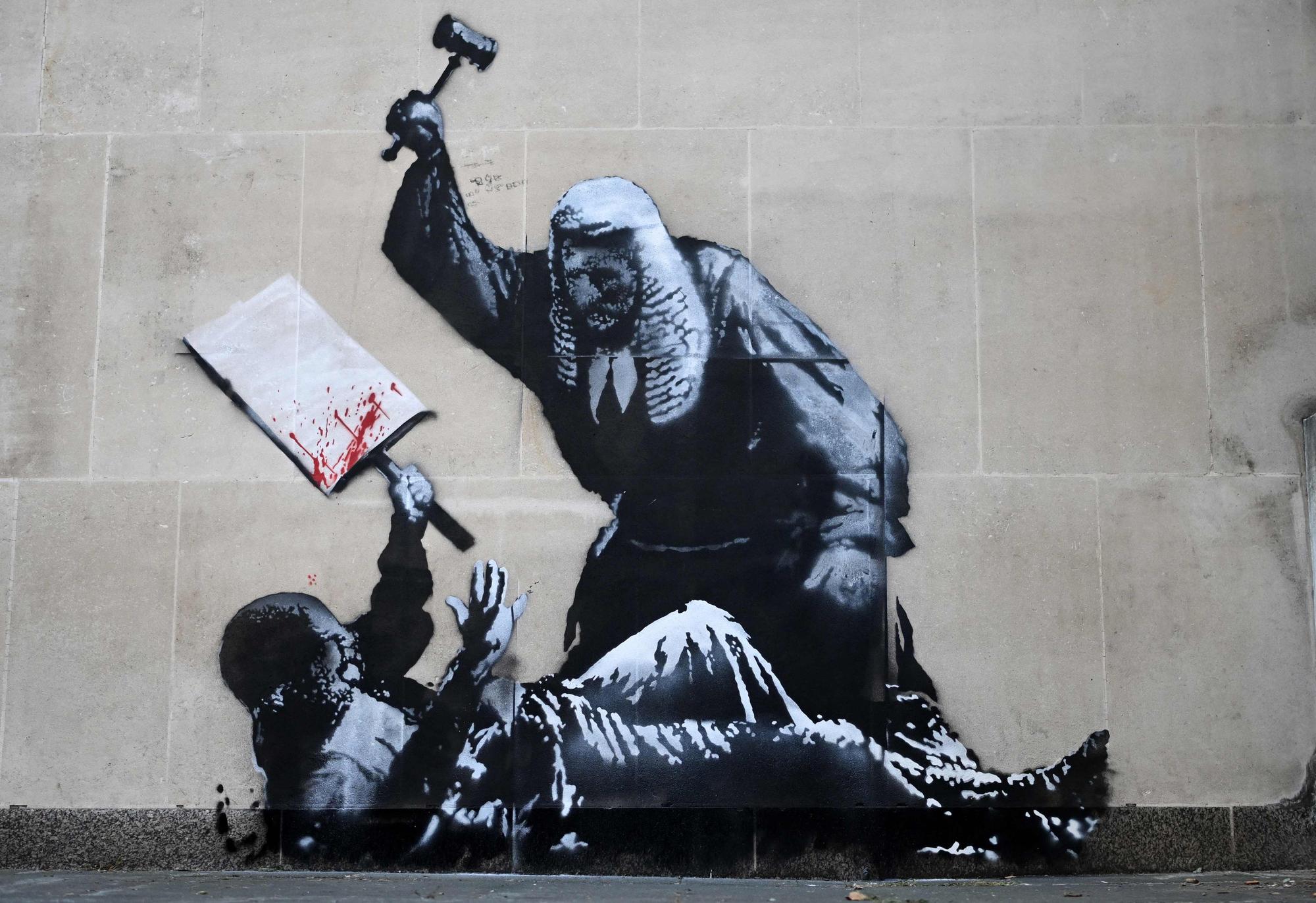 Das Graffiti zeigt einen Richter, der einen Demonstranten mit einem Hammer schlägt.