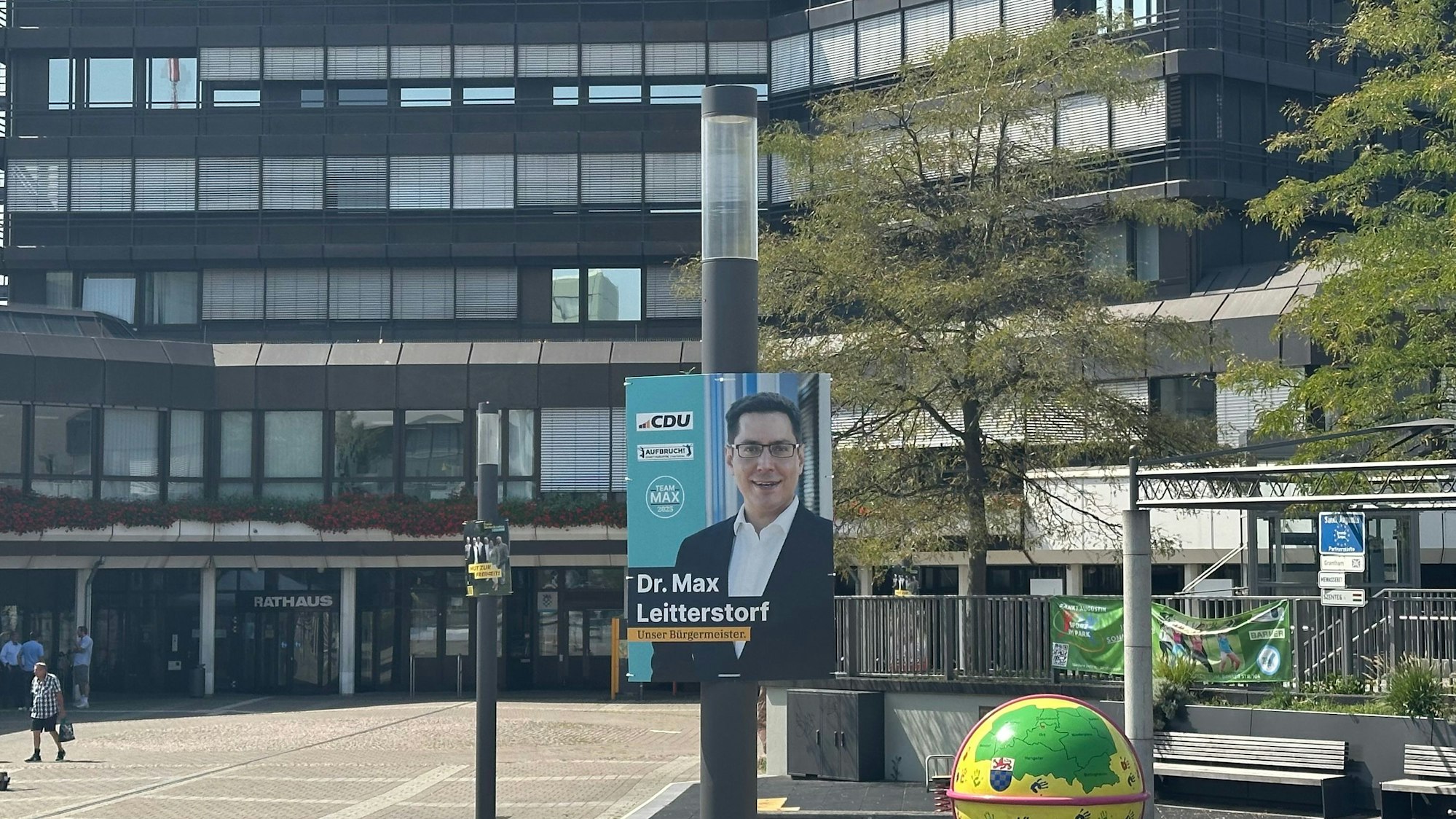 Wahlwerbung auf einem öffentlichen Platz vor einem Verwaltungsgebäude.