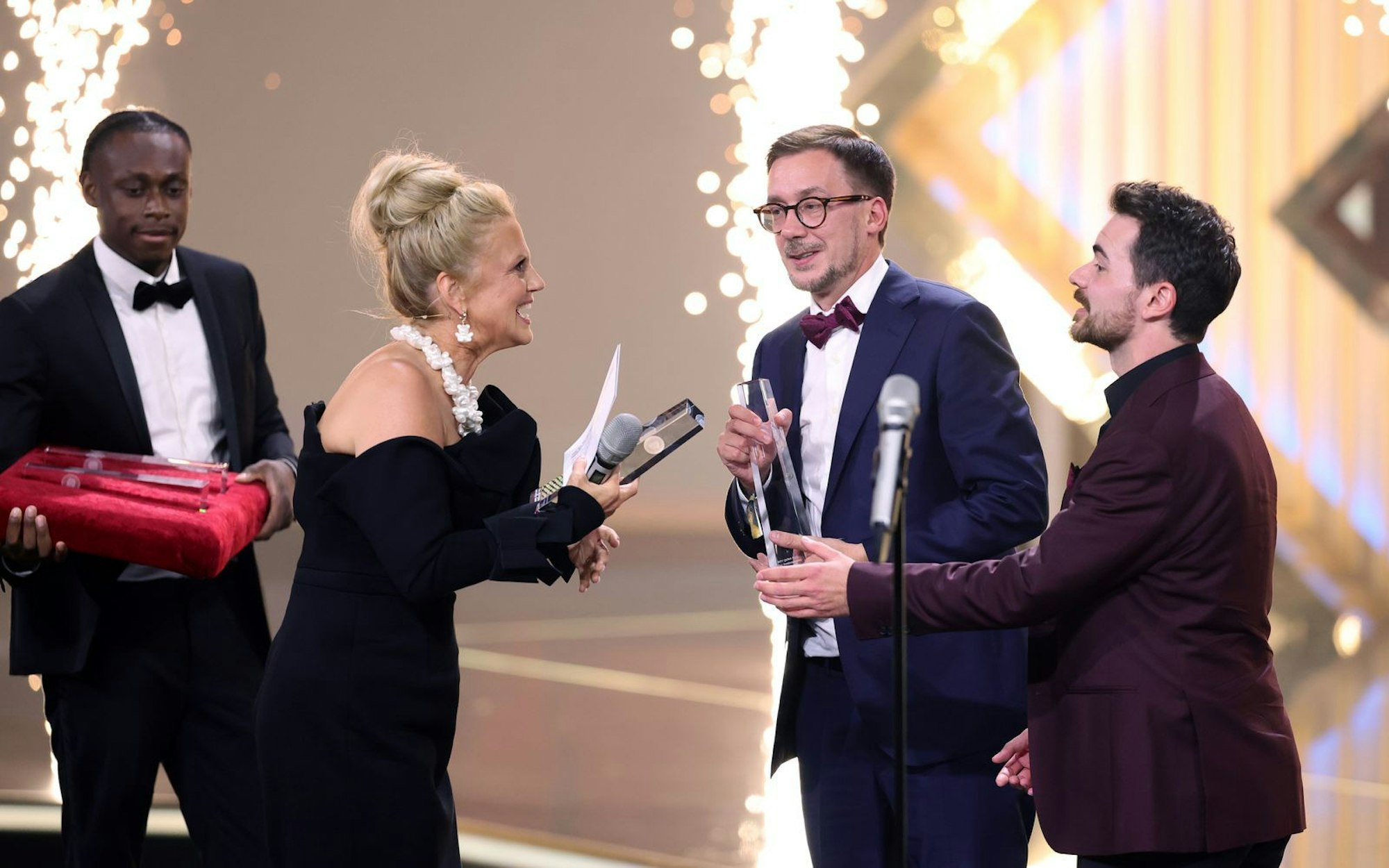 Thomas Schmitt (Zweiter von rechts) nahm von Barbara Schöneberger den Deutschen Fernsehpreis entgegen - in Vertretung des abwesenden Klaas Heufer-Umlauf. (Bild: 2025 Getty Images/Andreas Rentz)