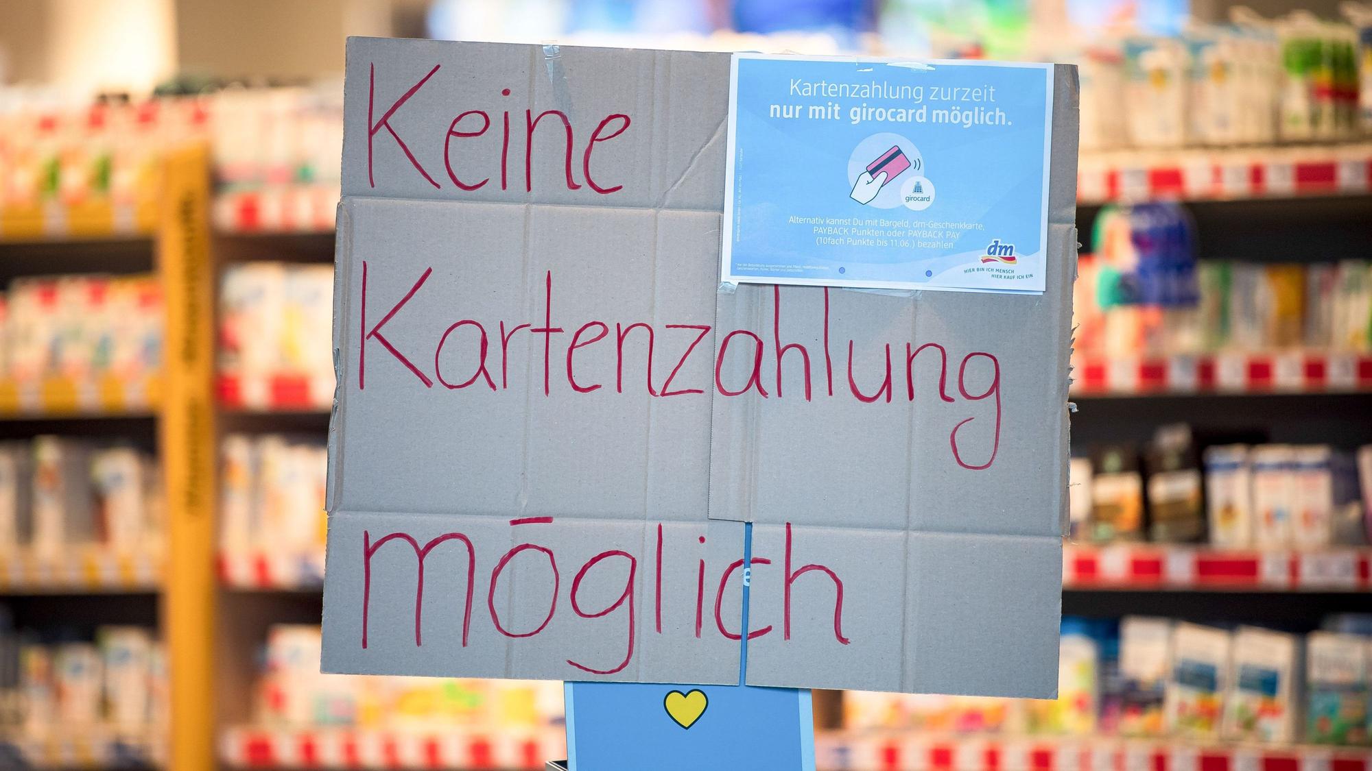 "Keine Kartenzahlung möglich" steht auf einem Schild am Eingang eines Drogeriemarktes.