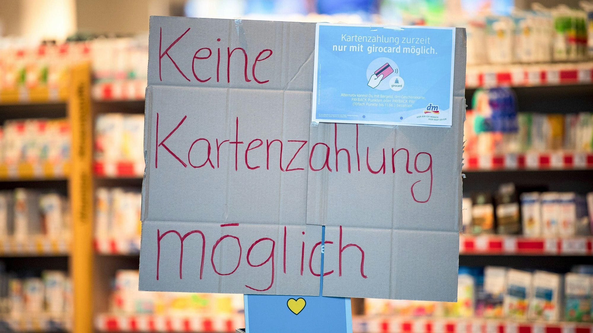 "Keine Kartenzahlung möglich" steht auf einem Schild am Eingang eines Drogeriemarktes.