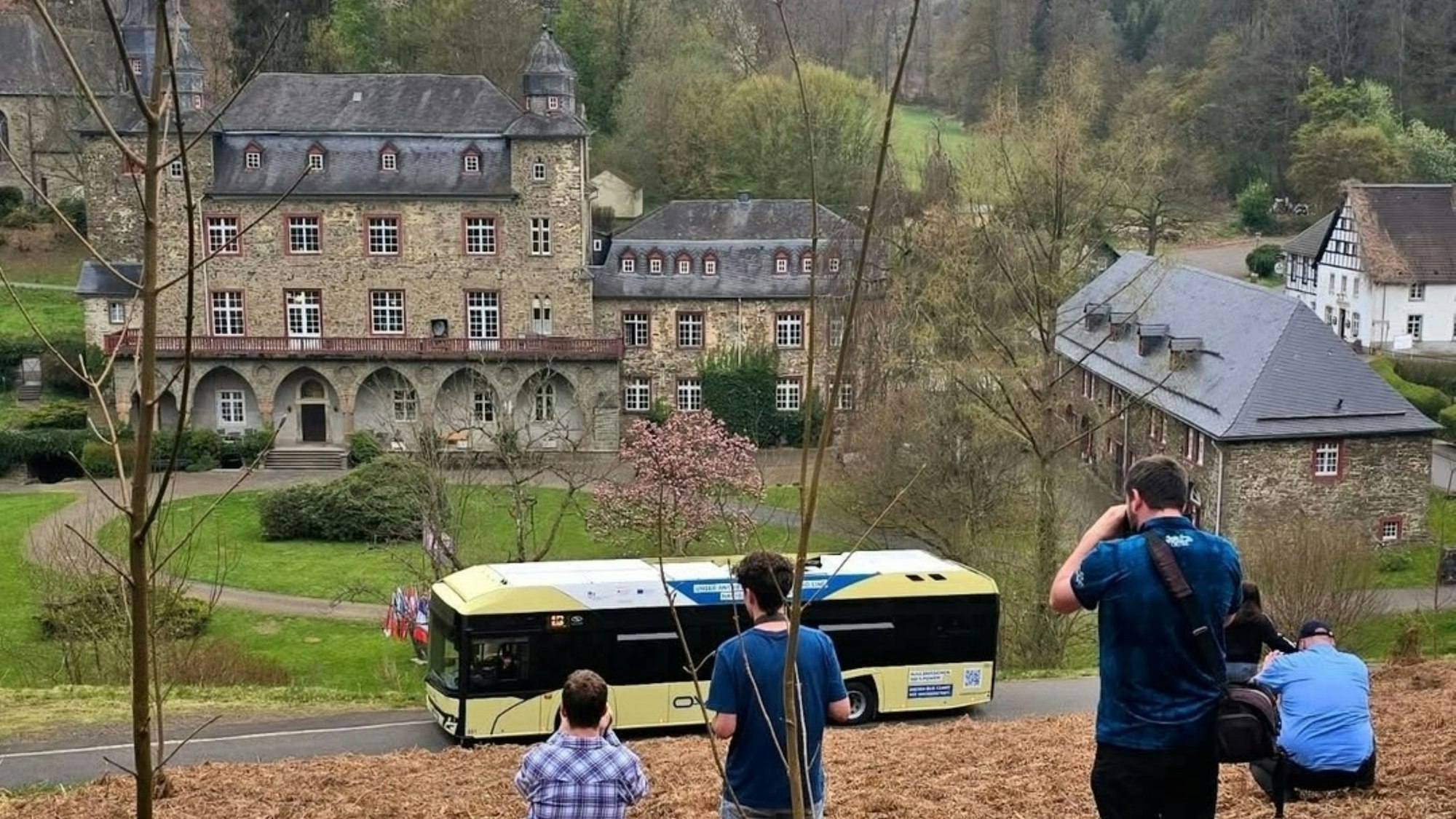 Hobbyfotografen fotografieren einen Wasserstoffbus vor Schloss Gimborn .