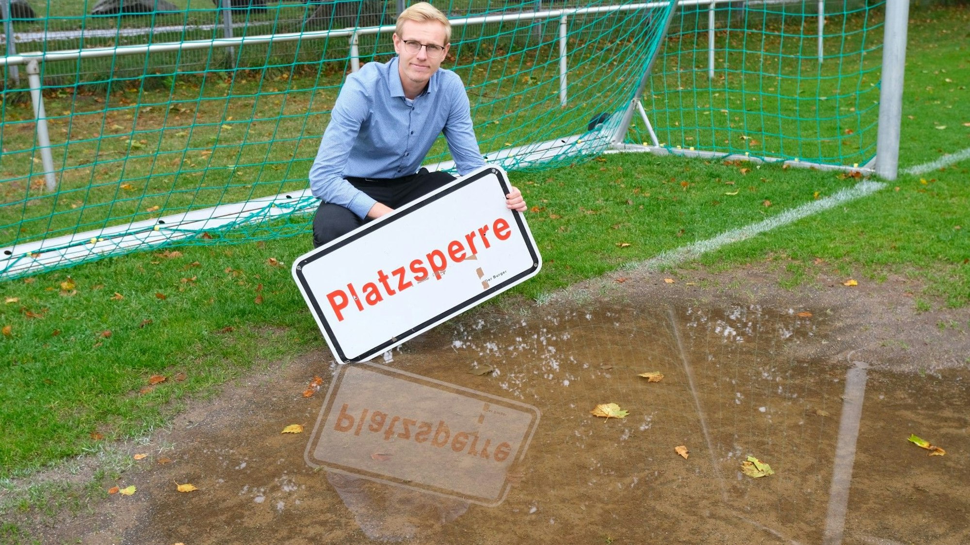 Christian Schneider, 1. Vorsitzender des FC Adler Meindorf, steht vor einer Pfütze im Strafraum.