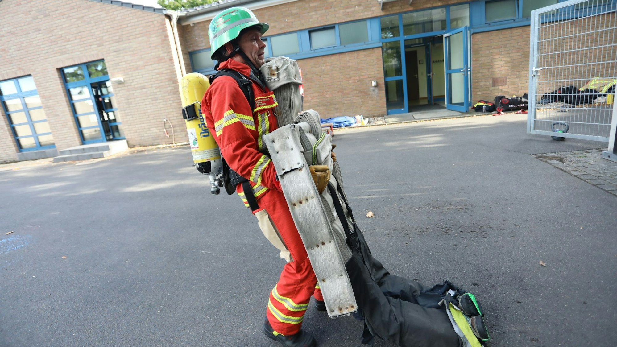 Ein Mann zieht eine schwere Puppe rückwärts gehend über einen Platz.