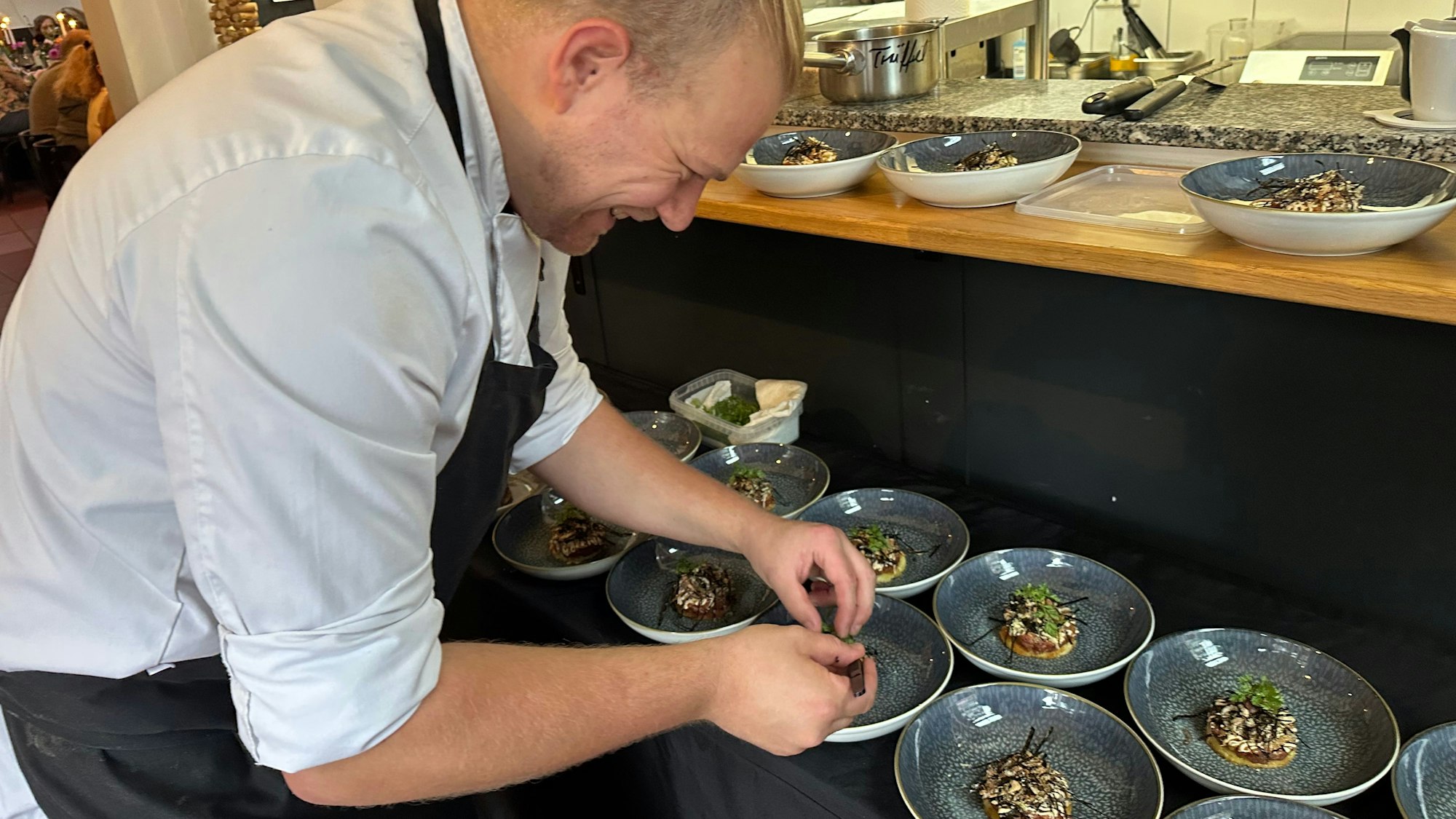 Timo Herrmann dekoriert gerade einen Gang des Menüs.