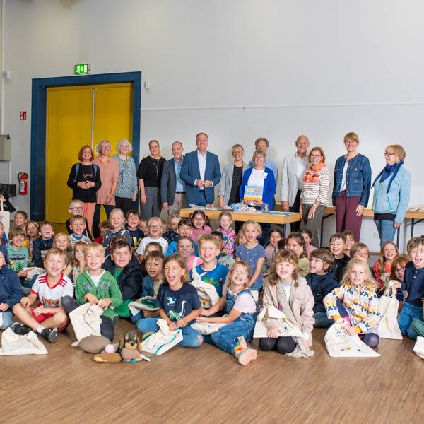 Das Foto zeigt die Schulkinder mit ihren Lesetaschen, dahinter die Vertreter der Stadt, der Leserfreunde und der Sponsoren.