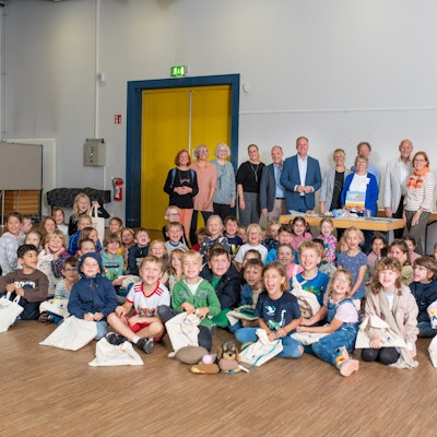 Das Foto zeigt die Schulkinder mit ihren Lesetaschen, dahinter die Vertreter der Stadt, der Leserfreunde und der Sponsoren.