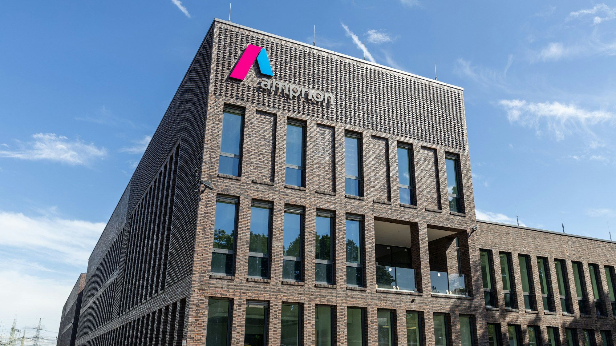 Das Foto zeigt eine Außenansicht des Neubaus mit Amprion-Logo auf der Fassade.