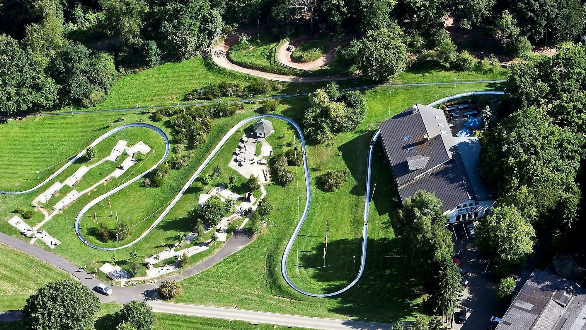 Das Luftbild zeigt die Sommerrodelbahn und die Gebäude in der Nachbarschaft.