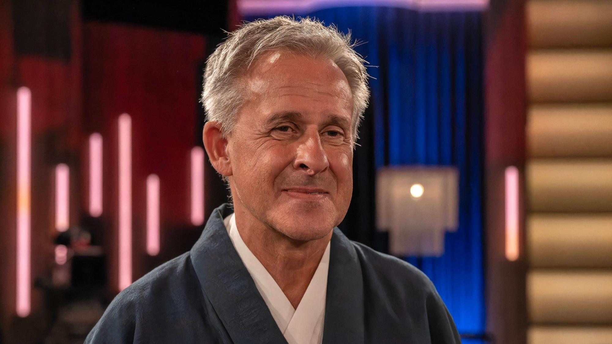 Pierre Littbarski lächelt vor der Aufnahme einer Talkshow.