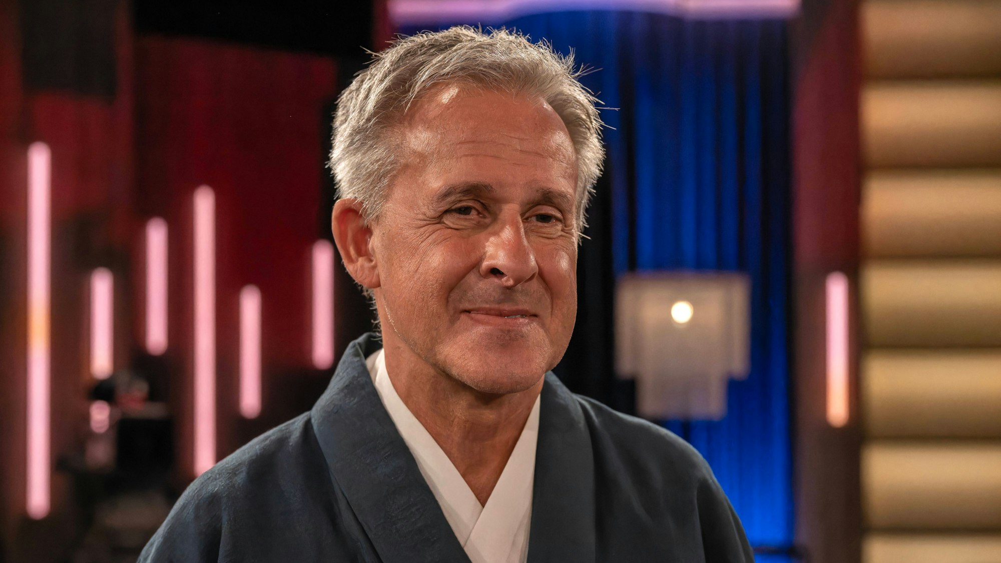 Pierre Littbarski lächelt vor der Aufnahme einer Talkshow.