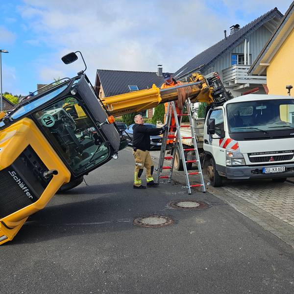 Der Hubarm eines umgekippter Radladers wird mit einer Leiter gestützt.