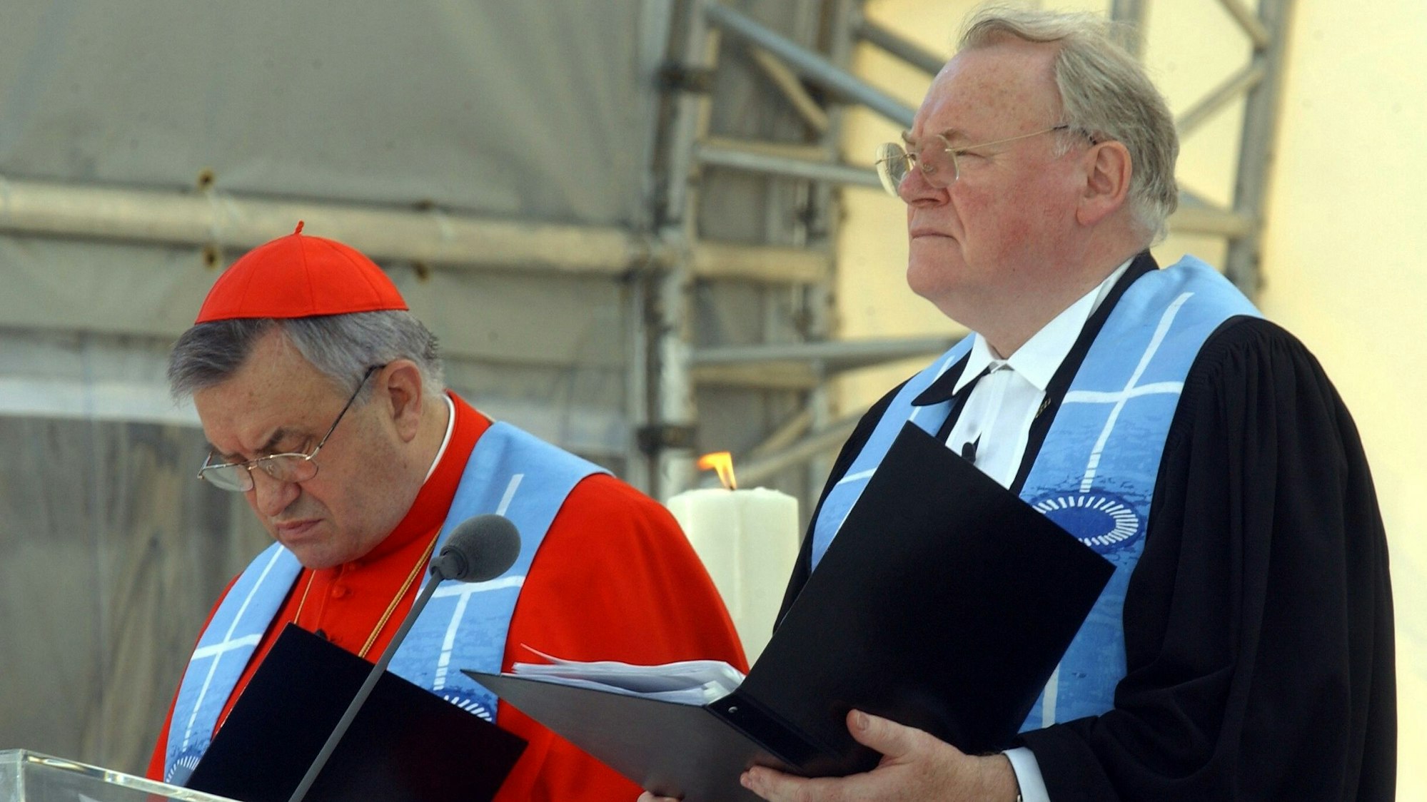 Gemeinsam stehen der Vorsitzende der evangelischen Kirche Deutschlands, Präses Manfred Kock (r) und der Vorsitzende der Deutschen Bischofskonferenz, Kardinal Karl Lehmann, am Sonntag (01.06.2003) vor dem Reichstag in Berlin beim Abschlussgottesdienstes des ersten ökumenischen Kirchentages auf dem Podium. Über zweihunderttausend Gläubige hatten sich bei strahlendem Sonnenschein vor dem Reichstag versammelt, um bei der Abschlussveranstaltung des Kirchentages dabei zu sein. Foto: Tim Brakemeier dpa/lbn +++ dpa-Bildfunk +++