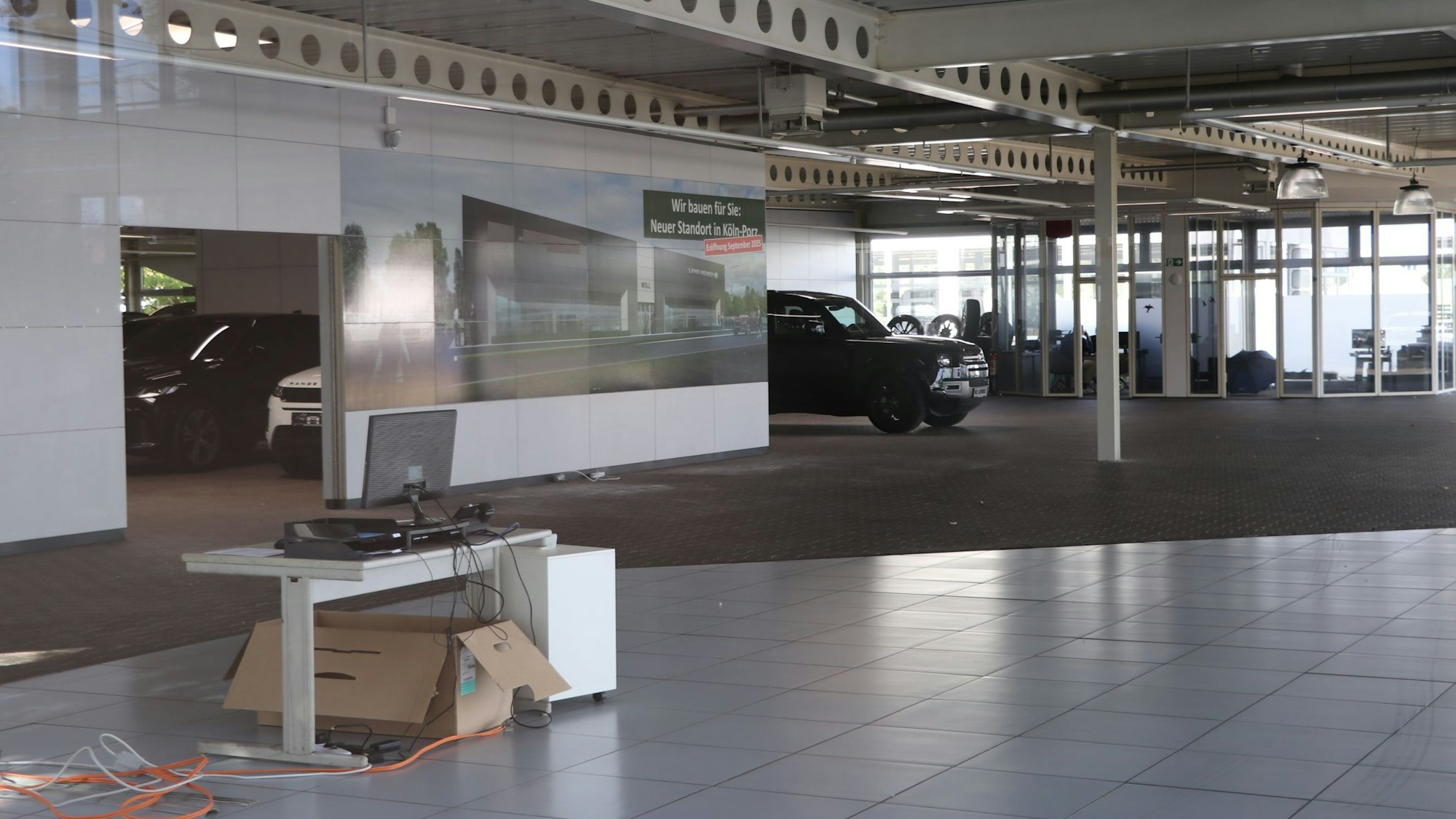 Auf dem Bild sind die fast leer geräumten Geschäftsräume zu sehen, im Vordergrund stehen ein einzelner Schreibtisch und ein Karton.