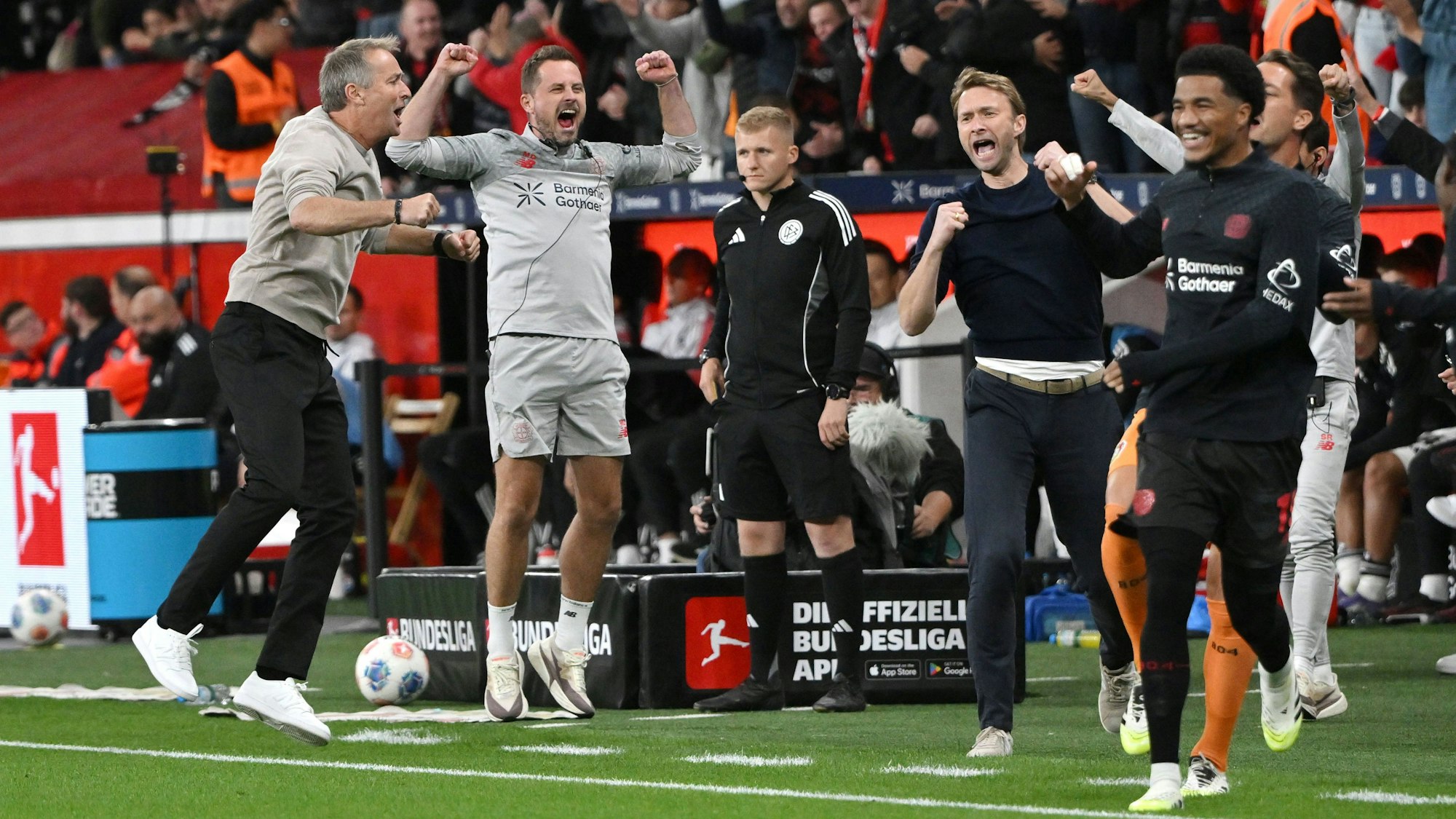 Leverkusens Trainer Kasper Hjulmand (v.li.), Co-Trainer Marcel Daum, Sportgeschäftsführer Simon Rolfes und Malik Tillman feiern.
