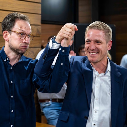 Das Bild zeigt die beiden Genannten nach der Wahl im Kreishaus. Jeder reißt einen Arm nach oben.