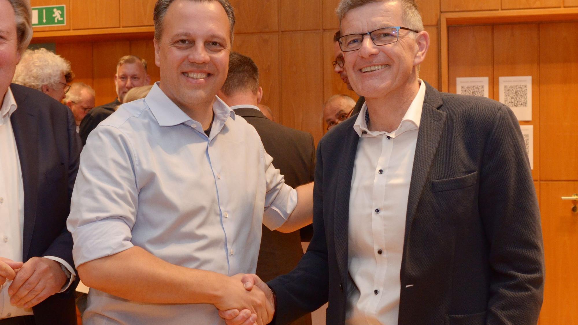 Sacha Reichelt und Michael Höllmann schütteln sich die Hände.