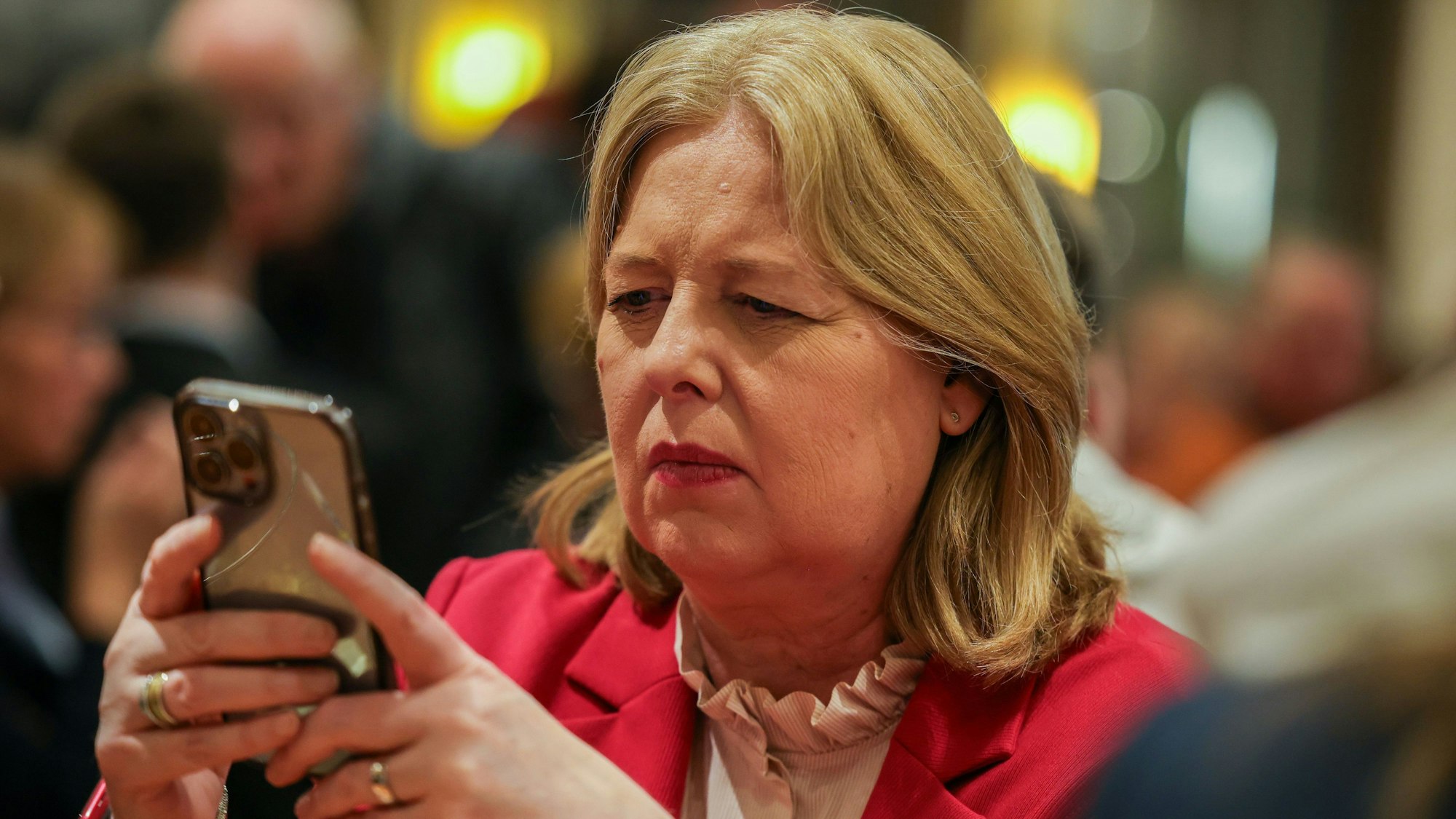 14.09.2025, Nordrhein-Westfalen, Duisburg: Bärbel Bas (SPD), Bundesministerin für Arbeit und Soziales und Co-Chefin ihrer Partei, schaut auf der Wahlparty der Duisburger SPD nach den Kommunalwahlen in Nordrhein-Westfalen auf ihr Smartphone. Foto: Christoph Reichwein/dpa +++ dpa-Bildfunk +++