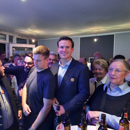 Eine Gruppe von Menschen drängt sich in einem Raum.