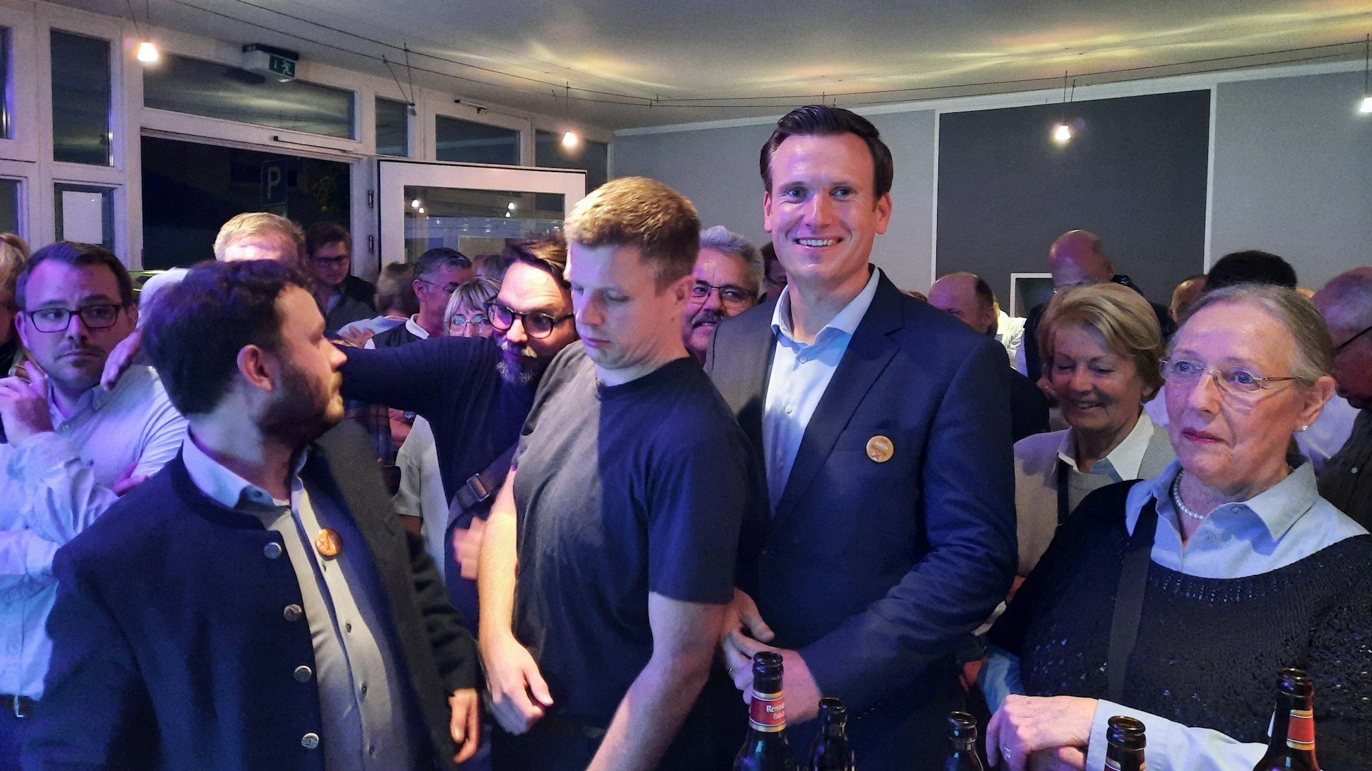 Viele Menschen drängen sich in einem Raum.