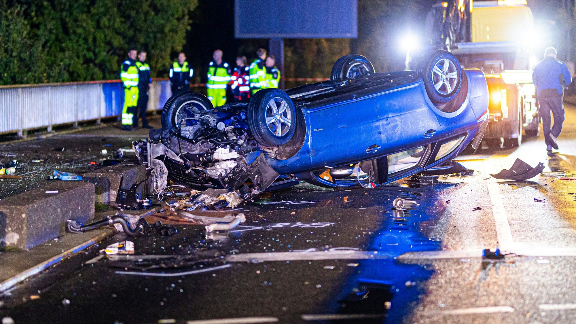 14.09.2025, Niedersachsen, Hannover: Ein verunfalltes Auto liegt auf dem Dach auf einer Brücke hinter Betonbaken. Foto: Moritz Frankenberg/dpa +++ dpa-Bildfunk +++