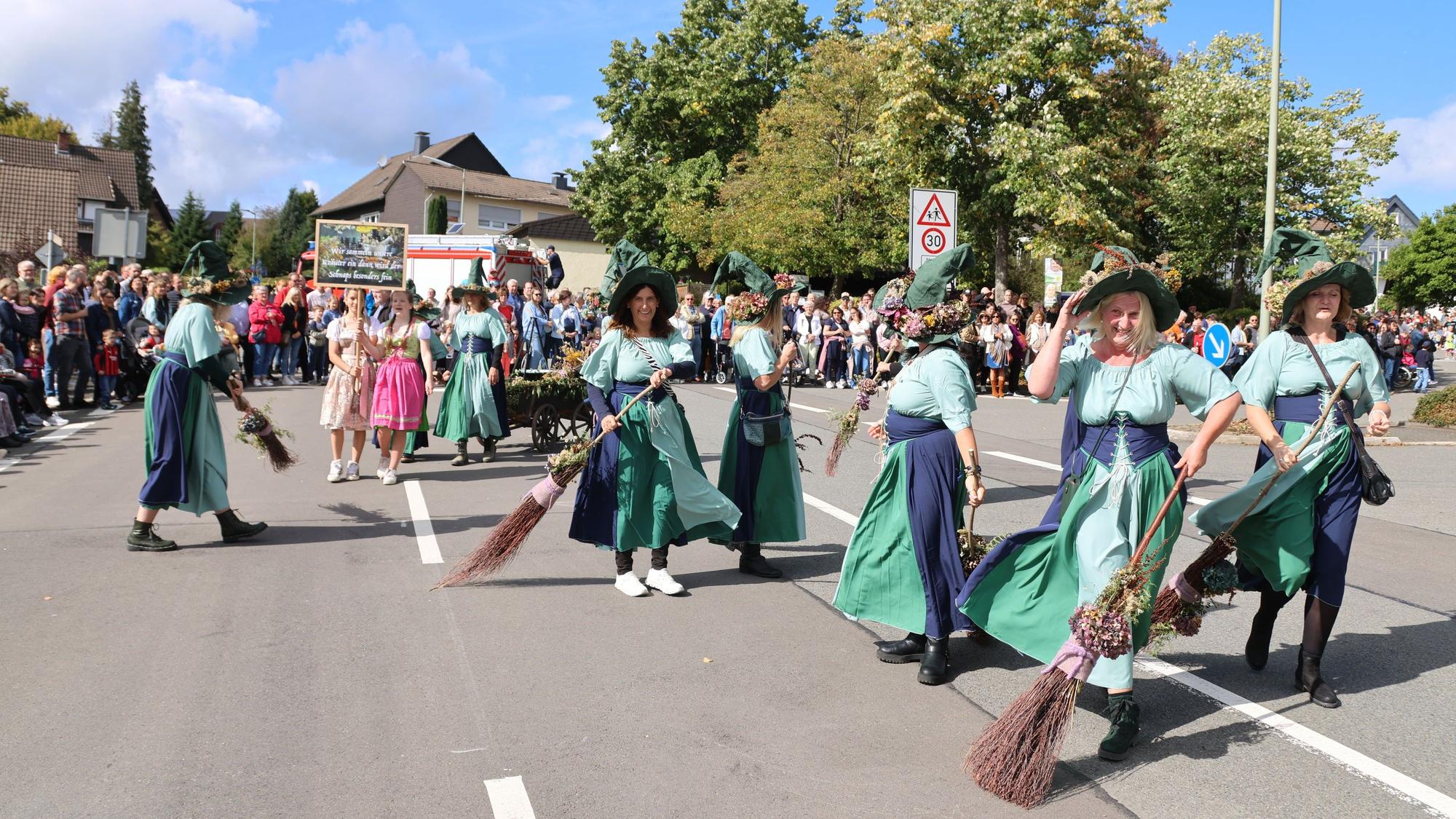 Verkleidet ziehen die Leute durch die Straßen in Lichtenberg bei schönem Wetter.