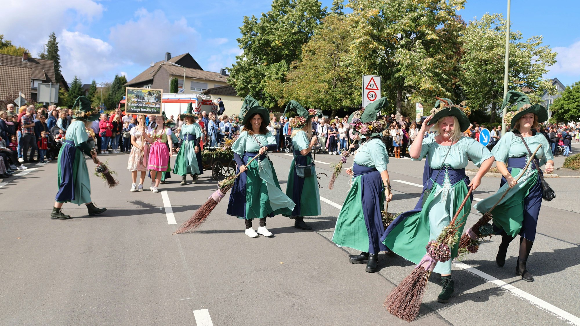 Verkleidet ziehen die Leute durch die Straßen in Lichtenberg bei schönem Wetter.