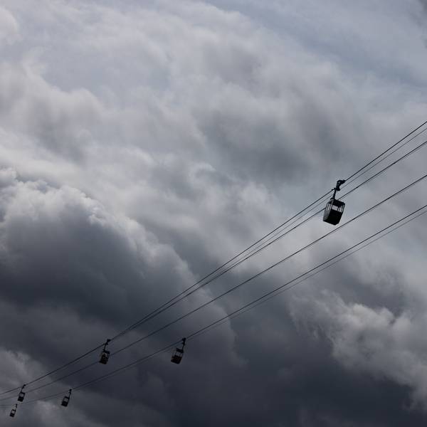 Die Seilbahn über den Rhein ist vor dunklen Wolken am Himmel zu sehen.