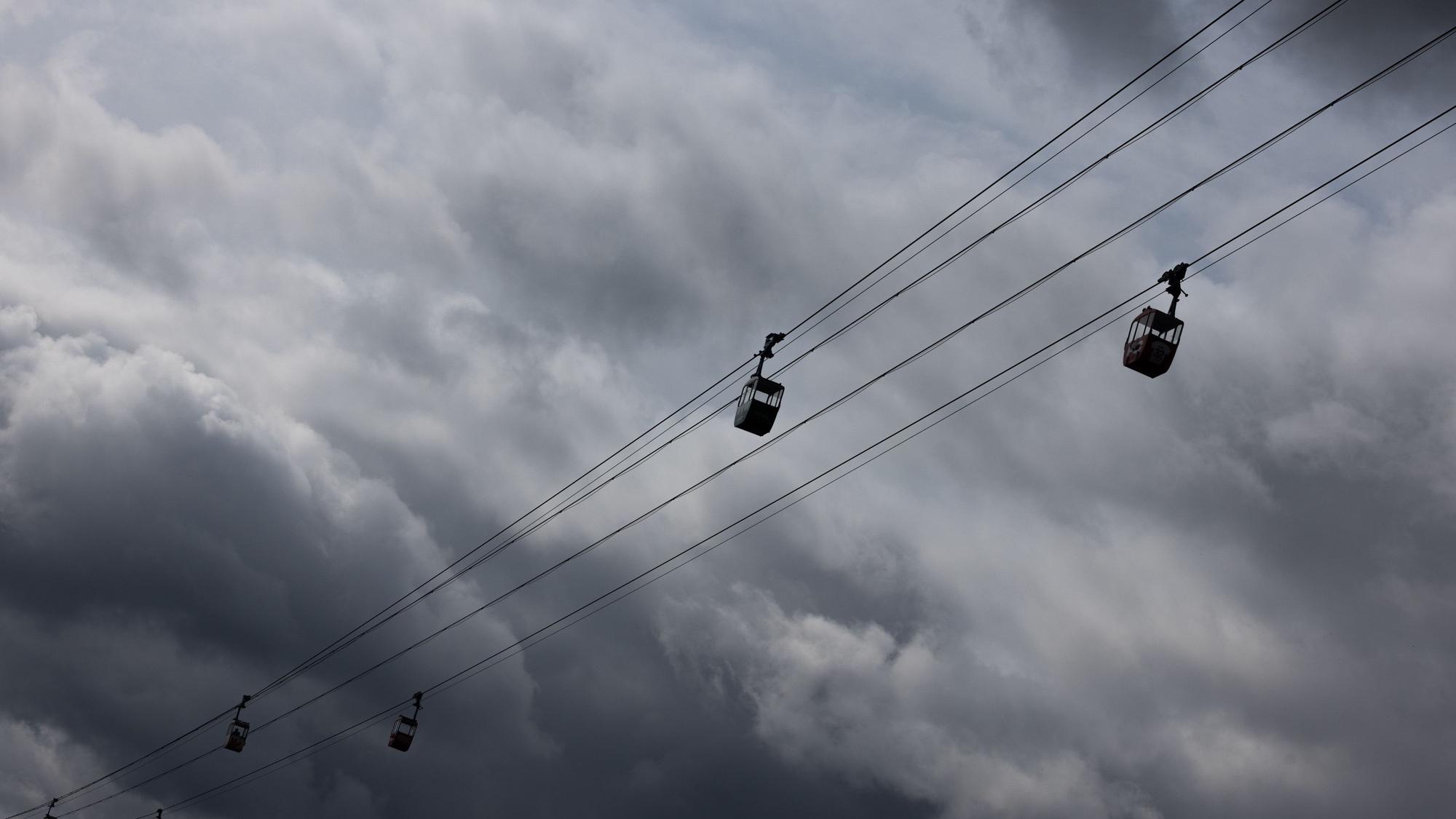 Eine Seilbahn ist vor dunklen Wolken am Himmel zu sehen (Symbolfoto).