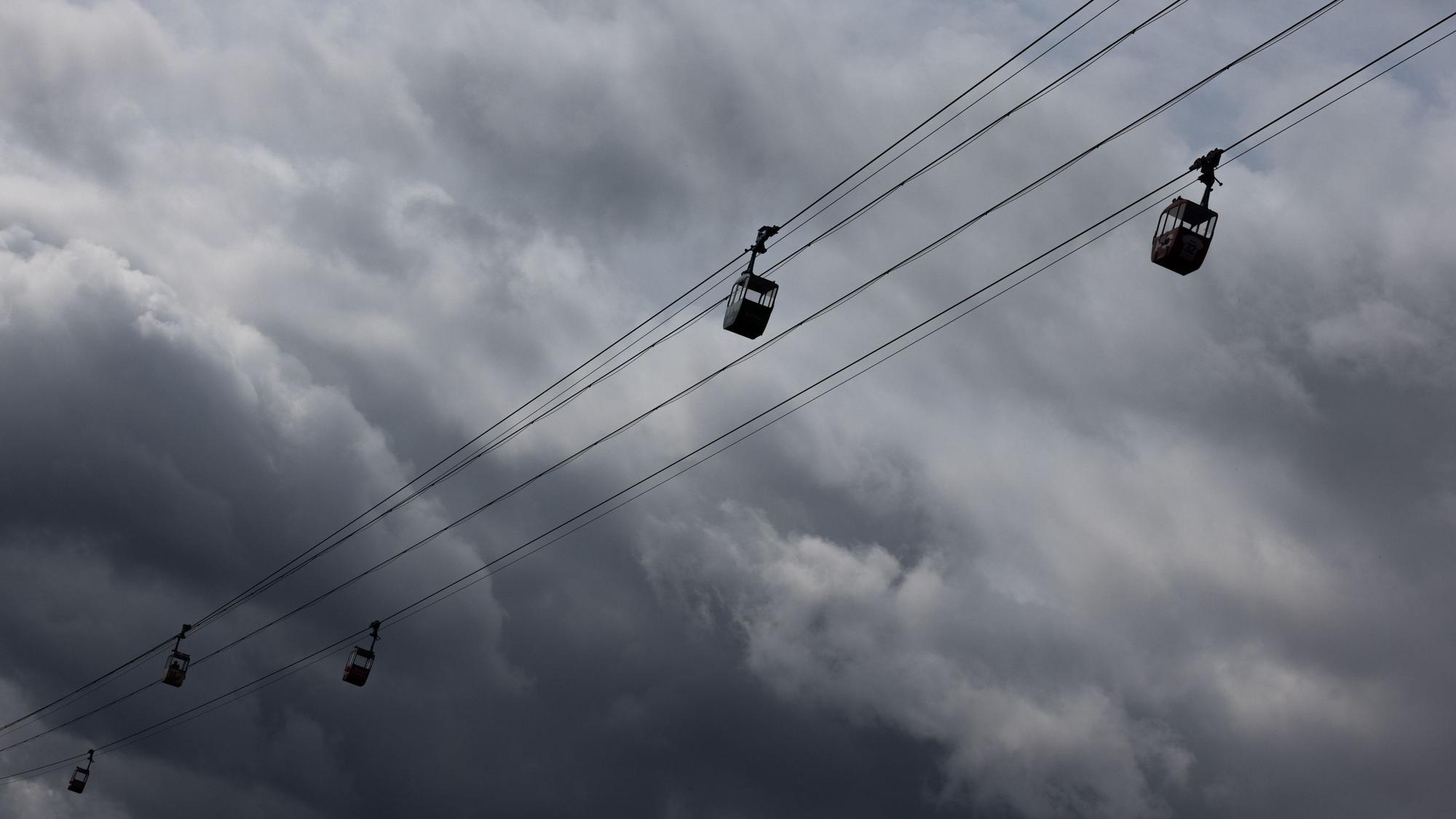 Eine Seilbahn über den Rhein ist vor dunklen Wolken am Himmel zu sehen (Symbolfoto).