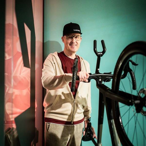Roman Arnold, Gründer und langjähriger Geschäftsführer des Fahrradbauers Canyon aus Koblenz hält den Lenker eines Rennrads fest und lächelt in die Kamera.