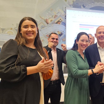 Zu sehen ist eine Gruppe von Frauen und Männern, die einen Wahlerfolg feiern.