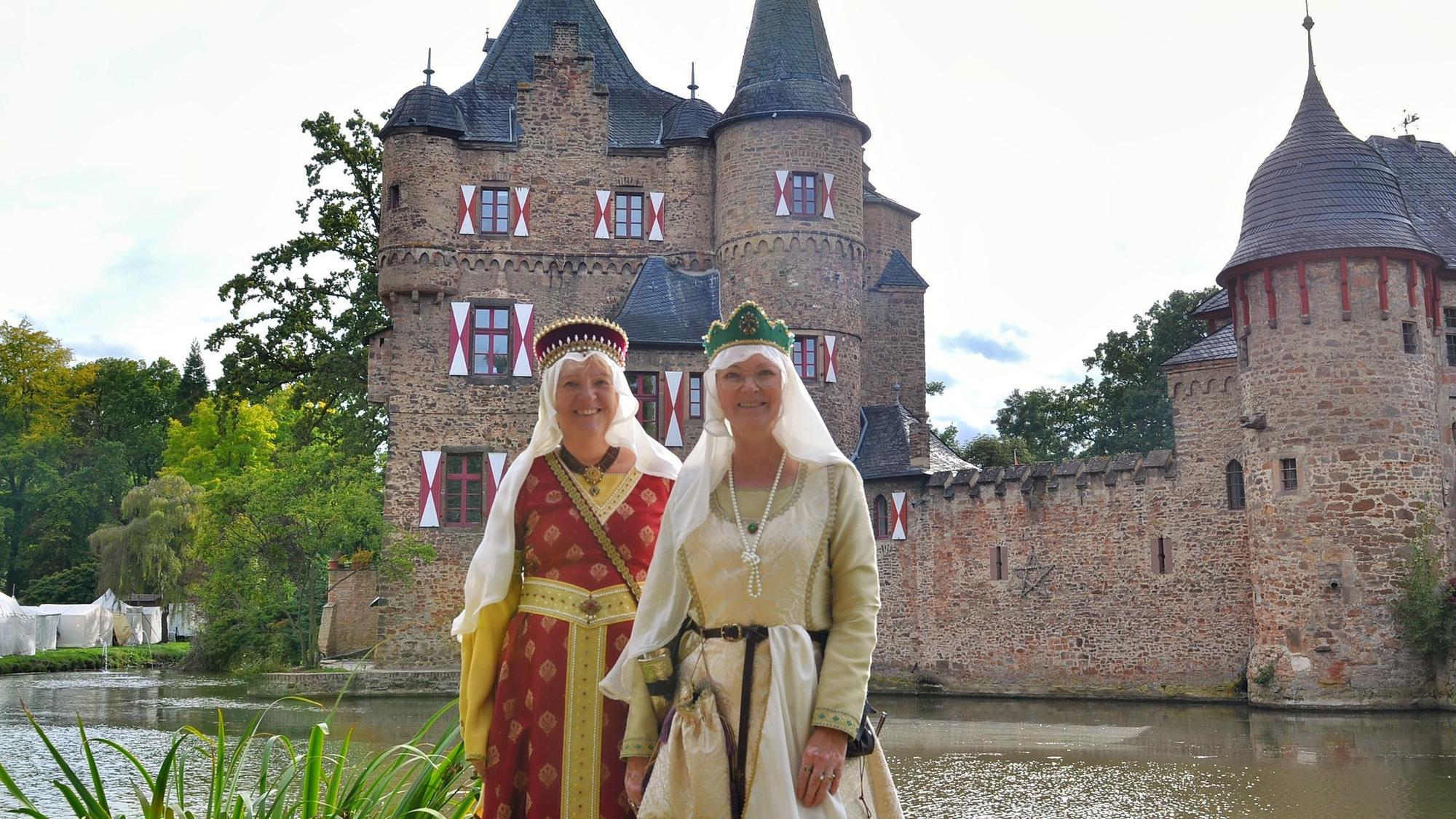 Zwei Freundinnen sind mittelalterlich gewandet und stehen vor der Burg Satzvey.