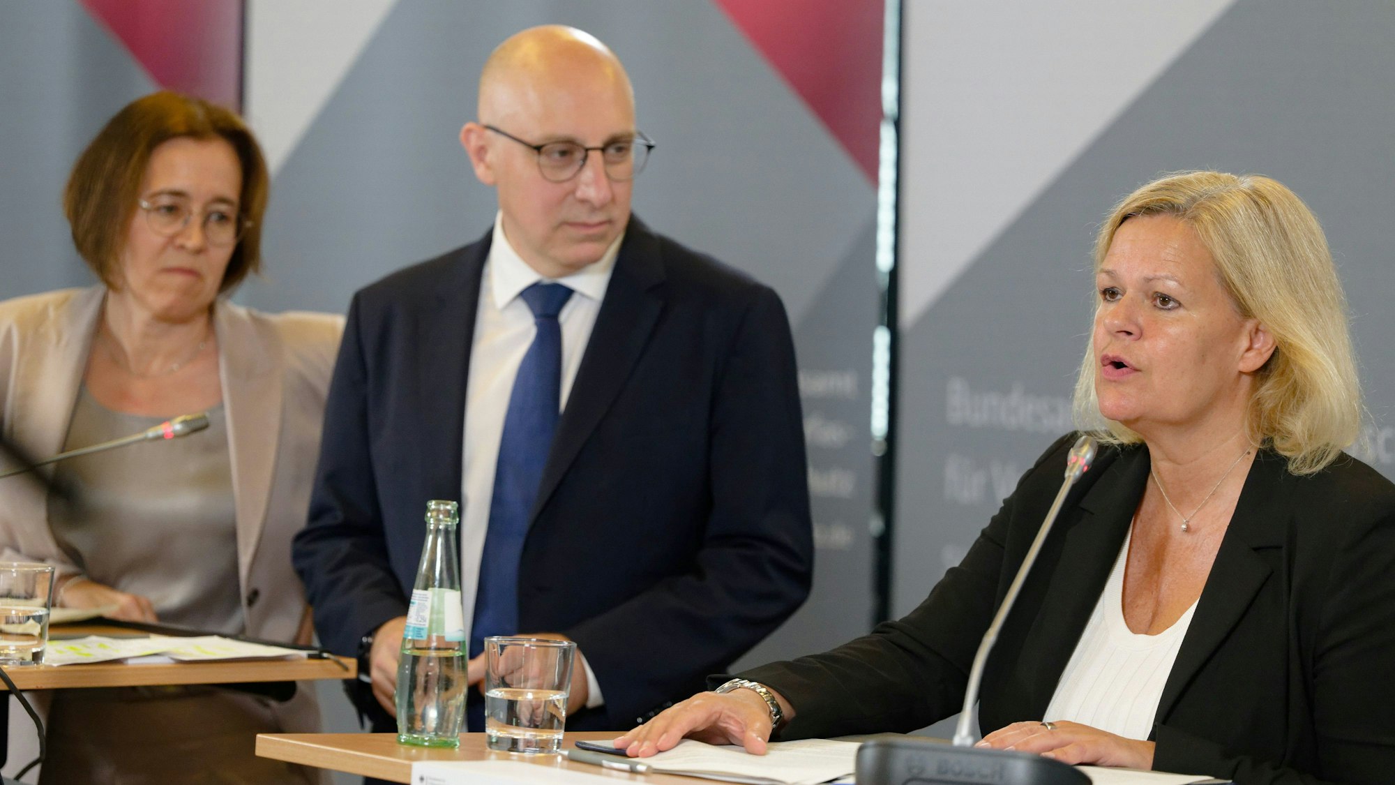 12.08.2024, Nordrhein-Westfalen, Köln: Bundesinnenministerin Nancy Faeser (SPD, r) gibt ein Statement für die Presse zusammen mit den BfV-Vizepräsidenten Silke Willems (l) und Sinan Selen (M), nachdem sie sich beim Bundesamt für Verfassungsschutz (BfV) über die aktuelle Sicherheitslage informiert hat. Foto: Henning Kaiser/dpa +++ dpa-Bildfunk +++