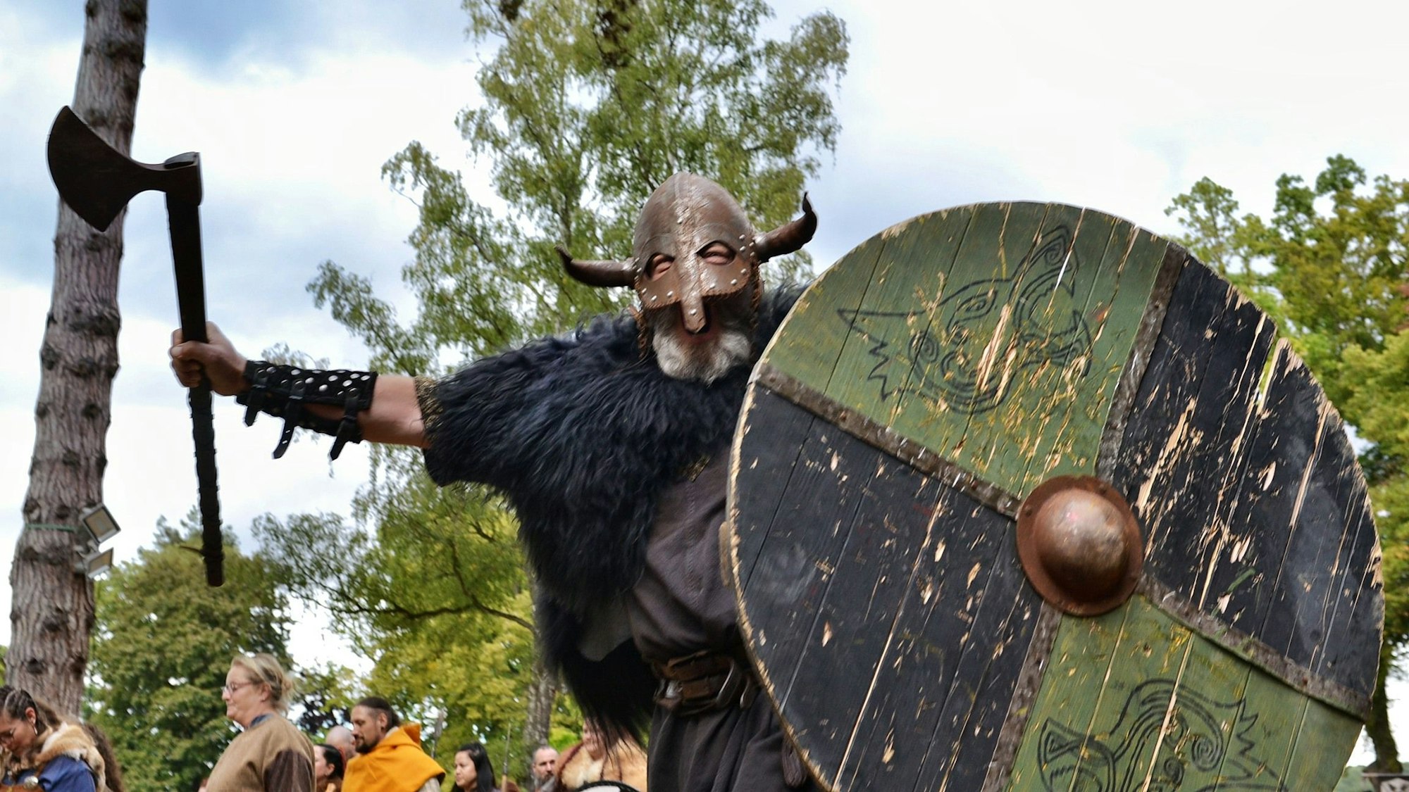 Ein Ritter mit komplett verdecktem Gesicht trägt einen gewaltigen Schild und eine Axt in den Händen.