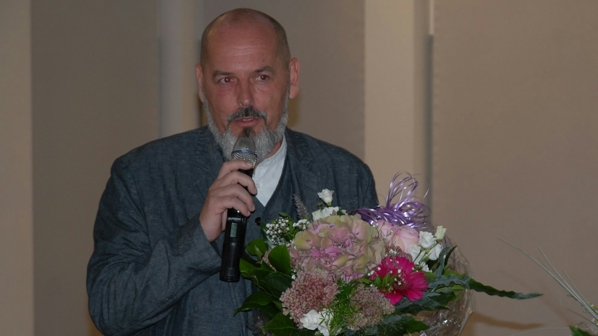 Ein Mann hält einen Blumenstrauß.