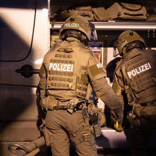 Beamte eines Spezialeinsatzkommandos (SEK) der Polizei agieren in einem Wohngebiet.