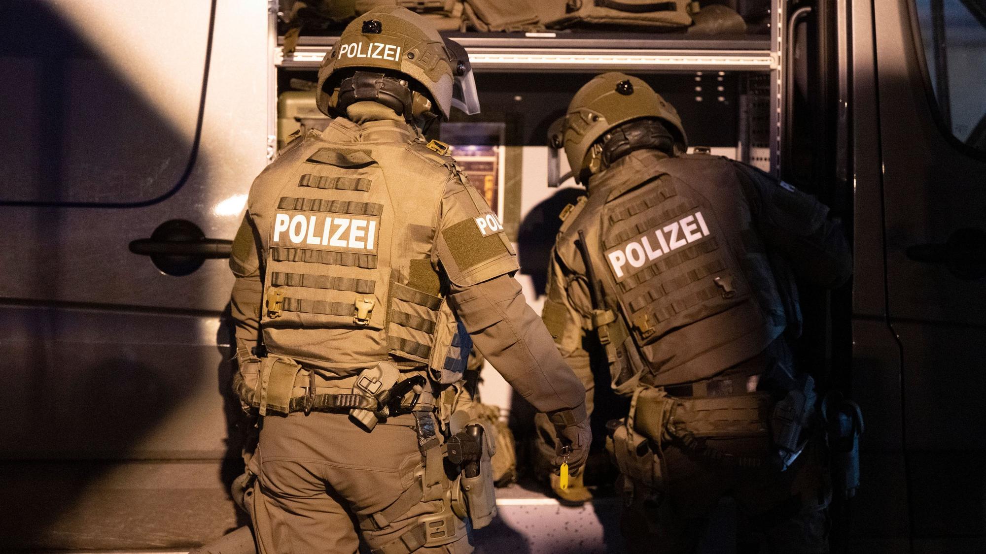 Beamte eines Spezialeinsatzkommandos (SEK) der Polizei agieren in einem Wohngebiet.