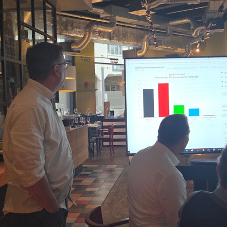 Kommunalwahl in Troisdorf: Der grüne Bürgermeisterkandidat Thomas Möws schaut gebannt auf den Bildschirm mit den Wahlergebnissen. Hier wie nahezu überall im Rhein-Sieg-Kreis stürzten die Grünen ab und zog die AfD mit deutlichem Gewinn in den Stadtrat ein.