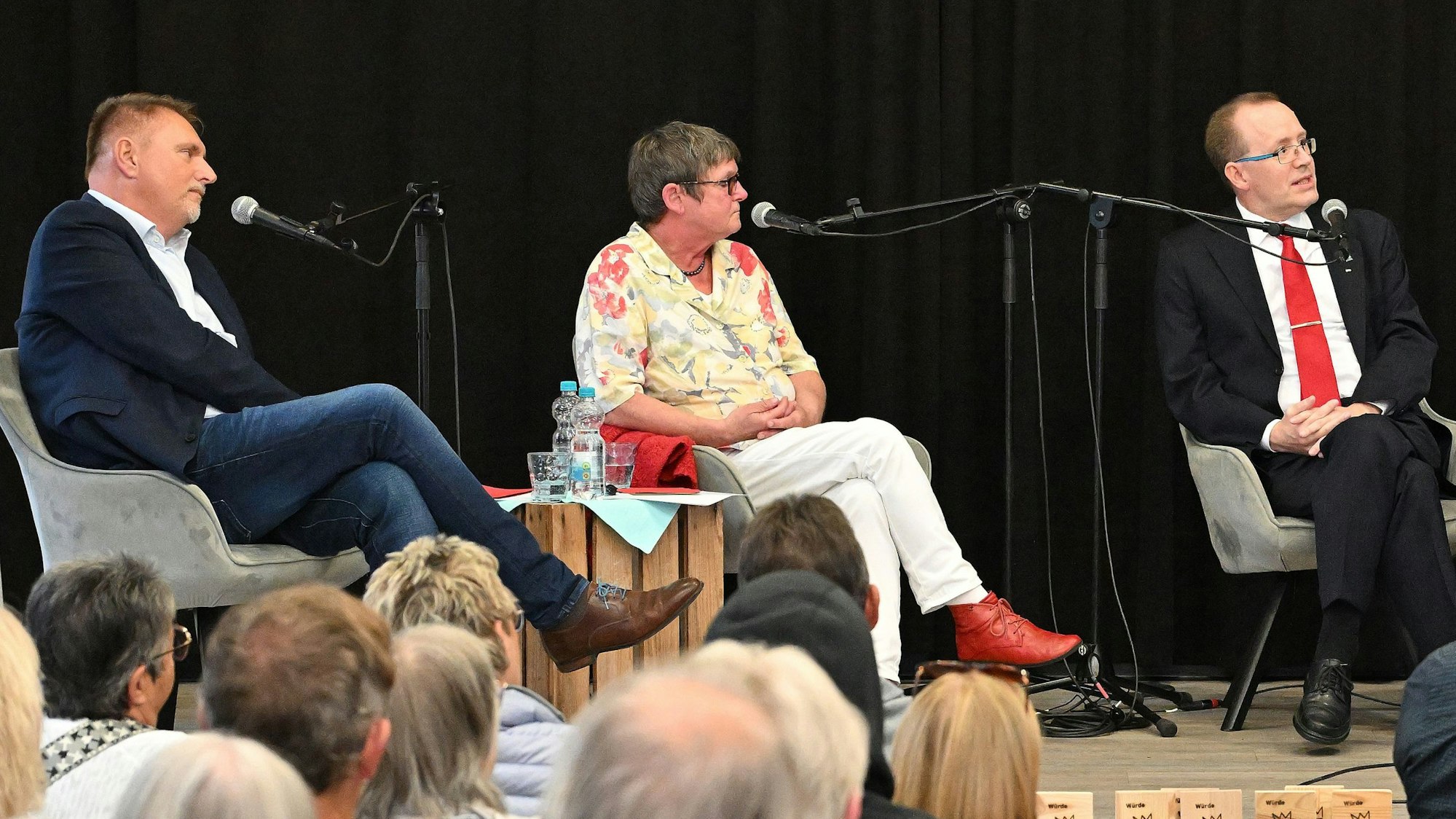 Die drei Overather Bürgermeisterkandidaten Michael Eyer (CDU), Dagmar Keller-Bartel (Grüne) und Hans Schlömer (SPD) sitzen bei einer Podiumsdiskussion nebeneinander.