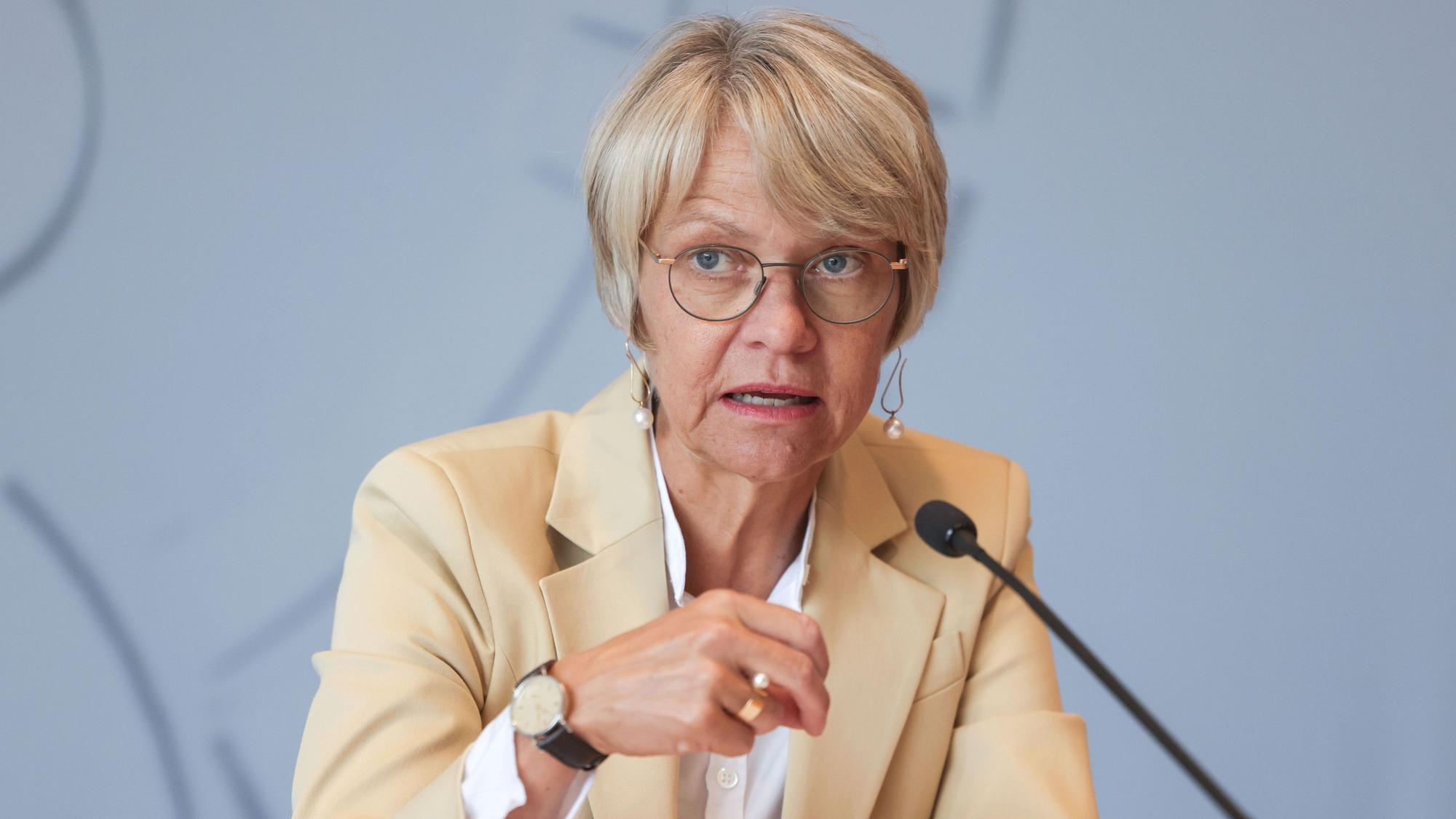NRW-Schulministerin Dorothee Feller (CDU) spricht vor einem Mikrofon. Ihre rechte Hand unterstützt ihre Aussage gestisch. Sie trägt eine weiße Bluse und einen cremefarbenen Blazer.