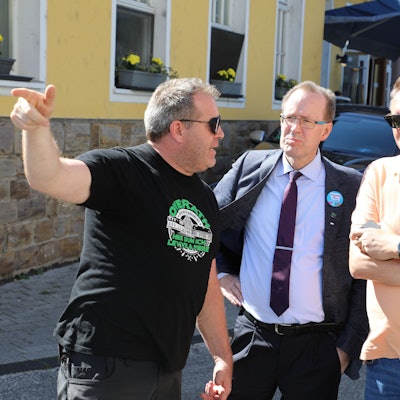 Die Stichwahlkandidaten Hans Schlömer (Mitte) und Michael Eyer lassen sich auf dem Overather Stadtfest den Notausgang zeigen.
