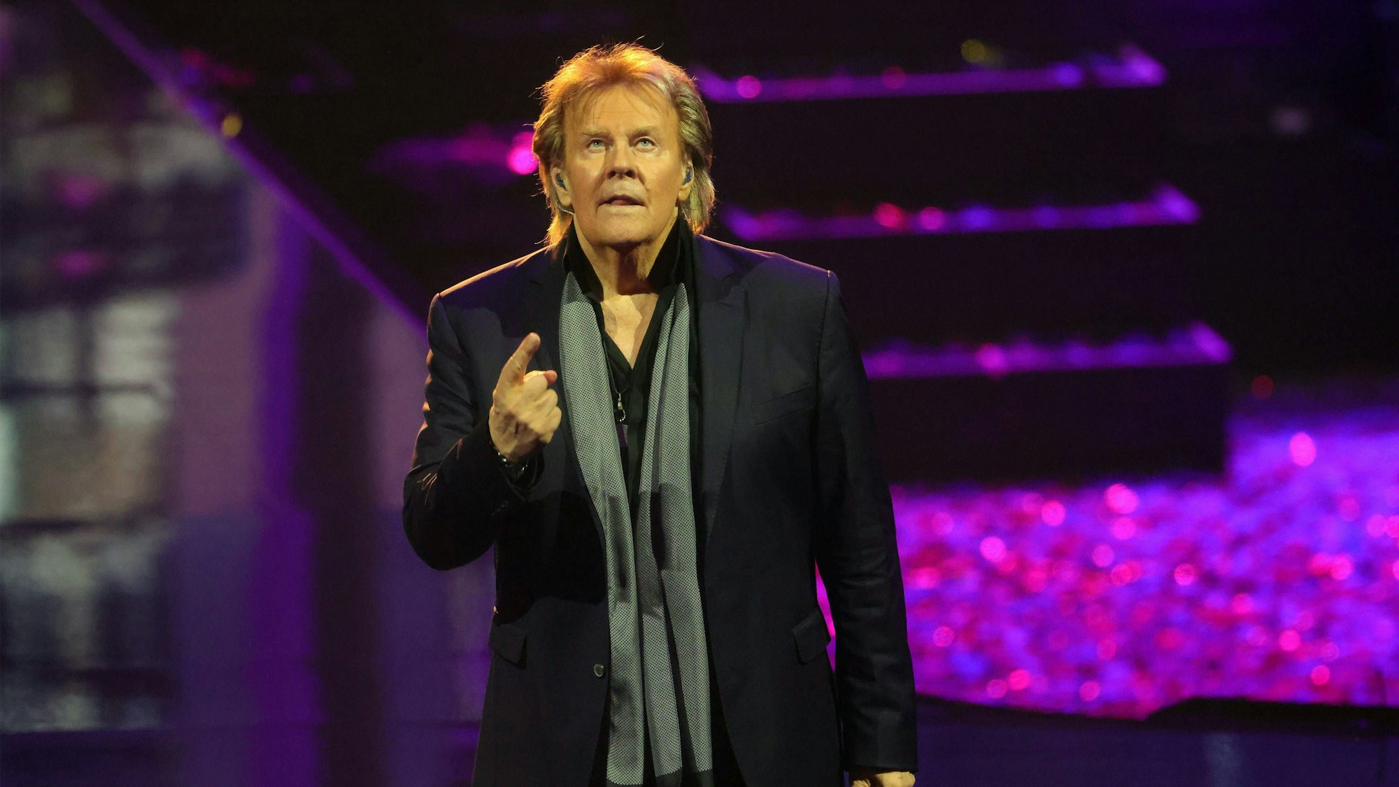 Howard Carpendale zeigt mit dem Finger nach oben.