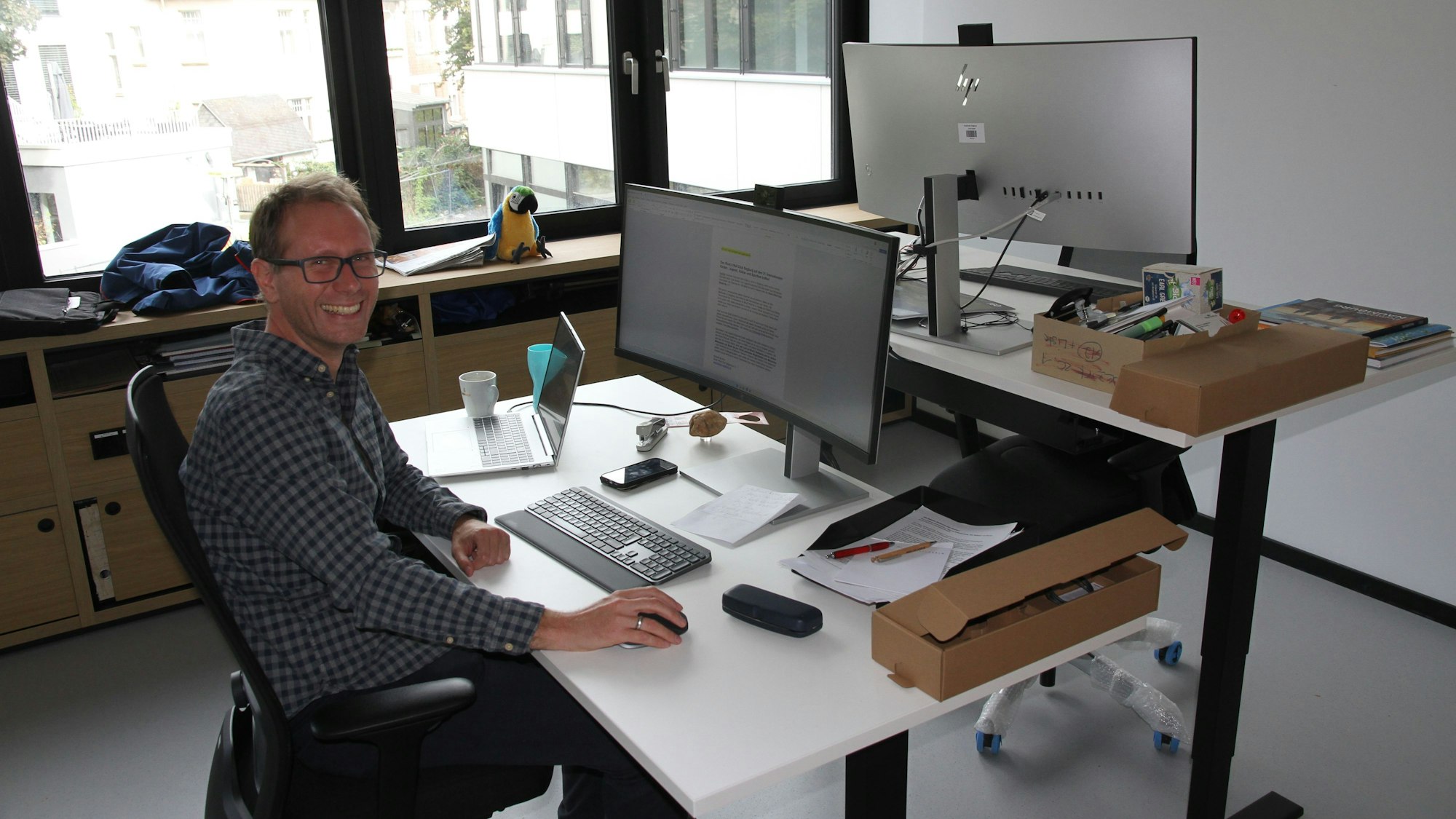 Umzug ins sanierte Siegburger Rathaus, Jan Gerull, Leiter der Pressestelle in seinem neuen Büro, rechts einer der neuen hoch einstellbaren Schreibtische