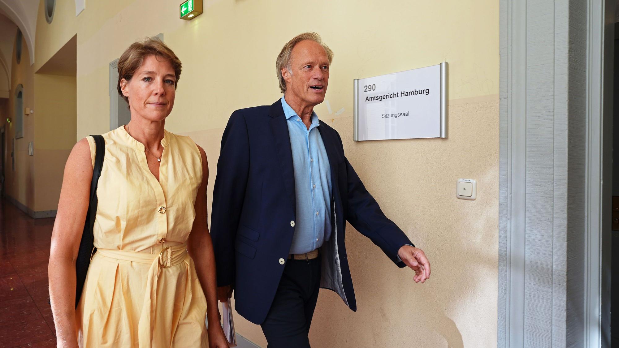Christina Block (l.), deutsche Gastronomin und Unternehmerin, und Gerhard Delling, ehemaliger Sportmoderator und Lebensgefährte von Block, kommen nach einer Pause im Prozess wegen mutmaßlicher Kindesentführung zum Gerichtssaal im Landgericht Hamburg zurück. (Archivbild)