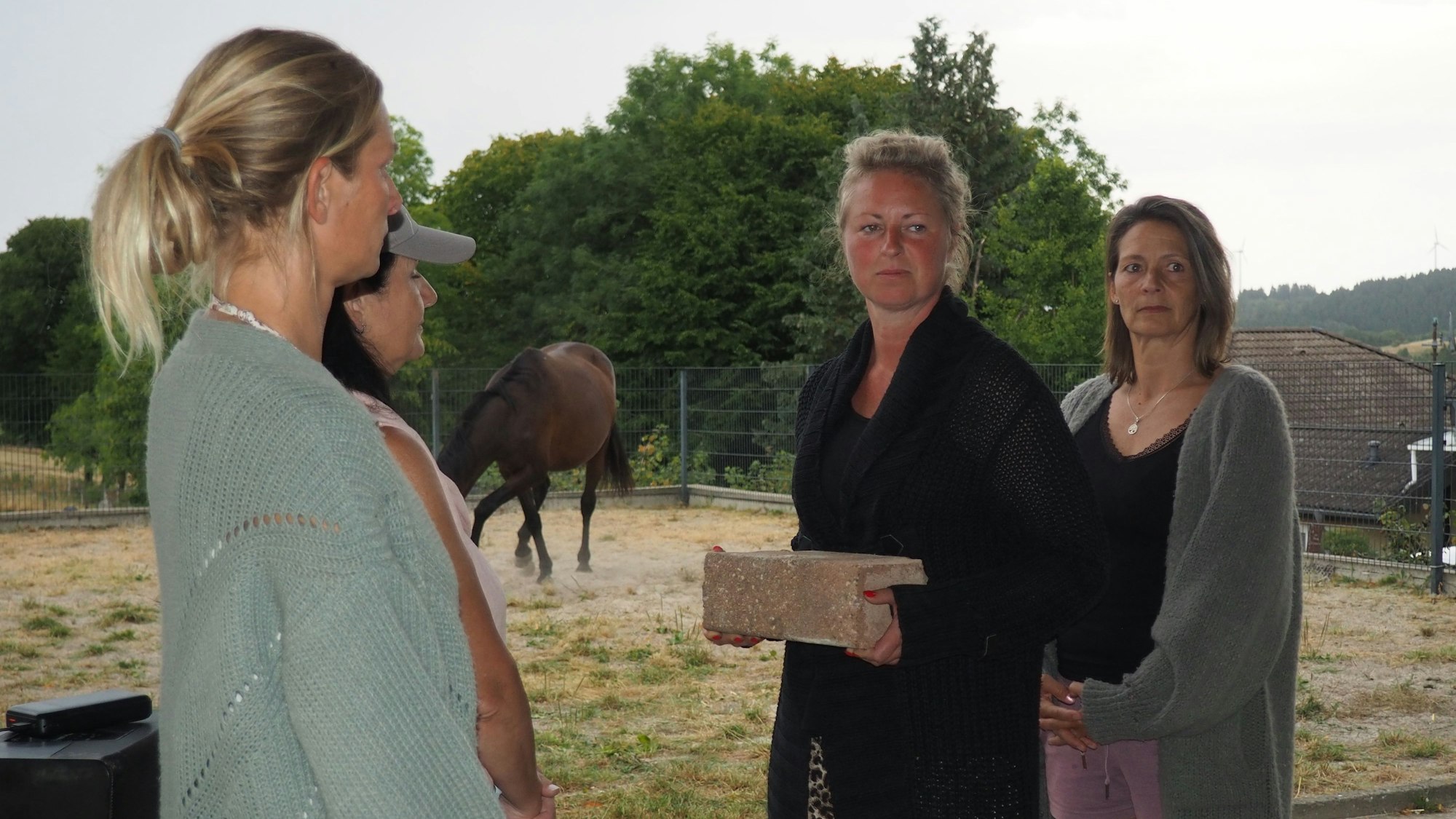 Eine Frau übergibt einer anderen einen Stein.