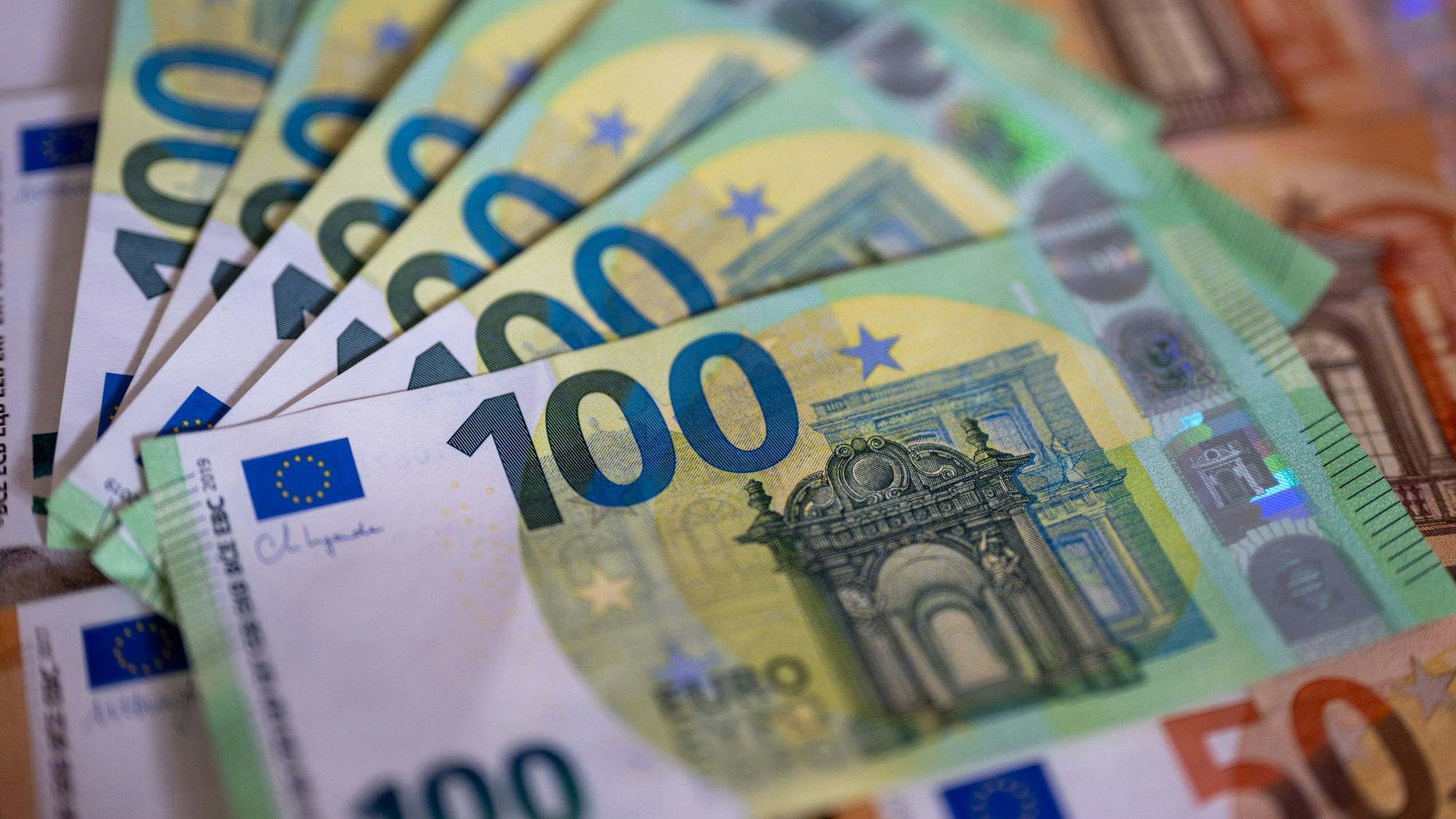 Geldscheine mit dem Wert von 100 und 50 Euro liegen auf einem Tisch.