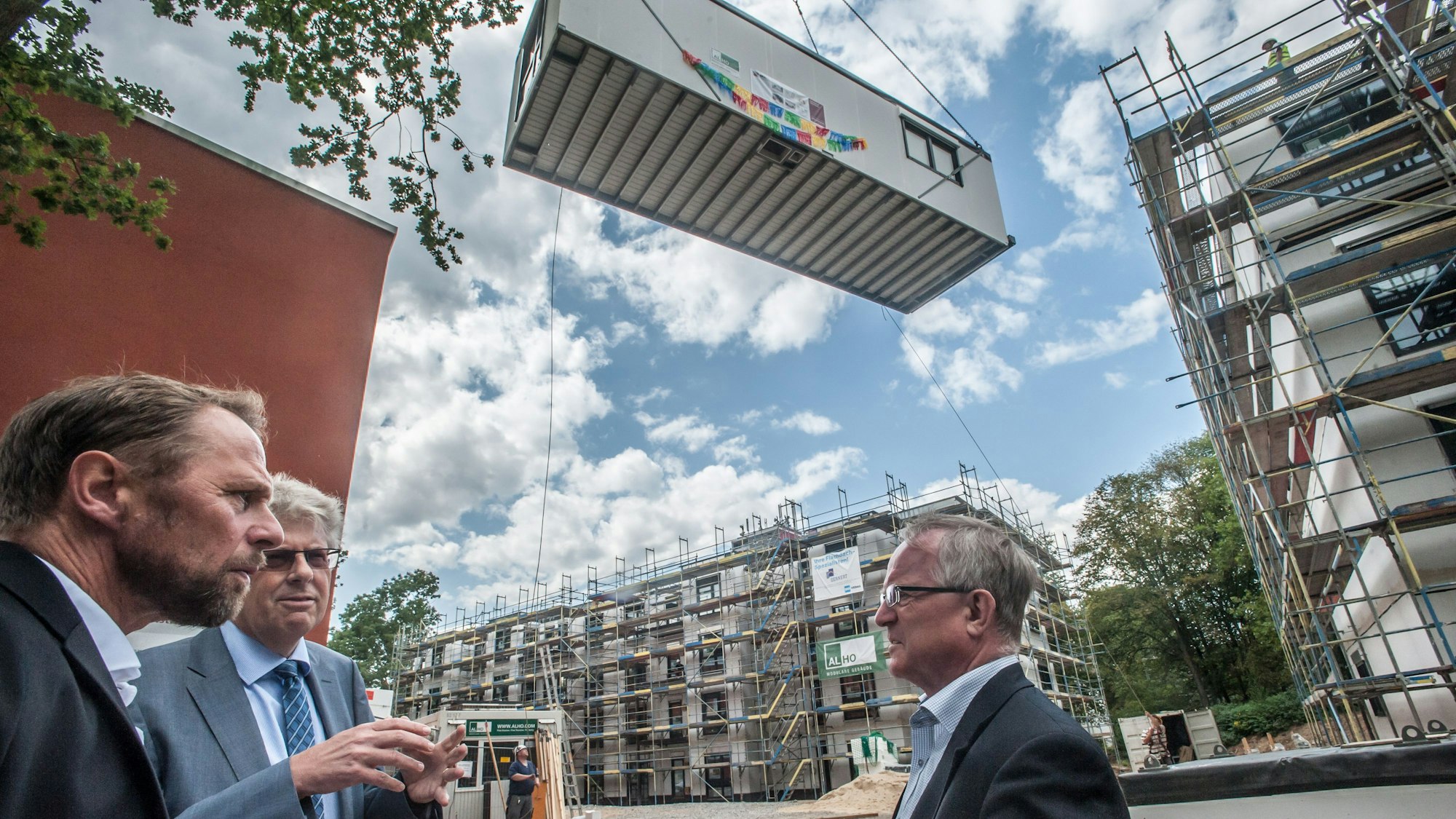 Uwe Richrath, Wolfgang Mues und Rüdiger Scholz stehen auf einer Baustelle an der Unstrutstraße.