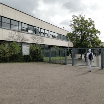 Eingang zum Schulhof und -Gebäude der Heinrich-Böll-Gesamtschule in Chorweiler.