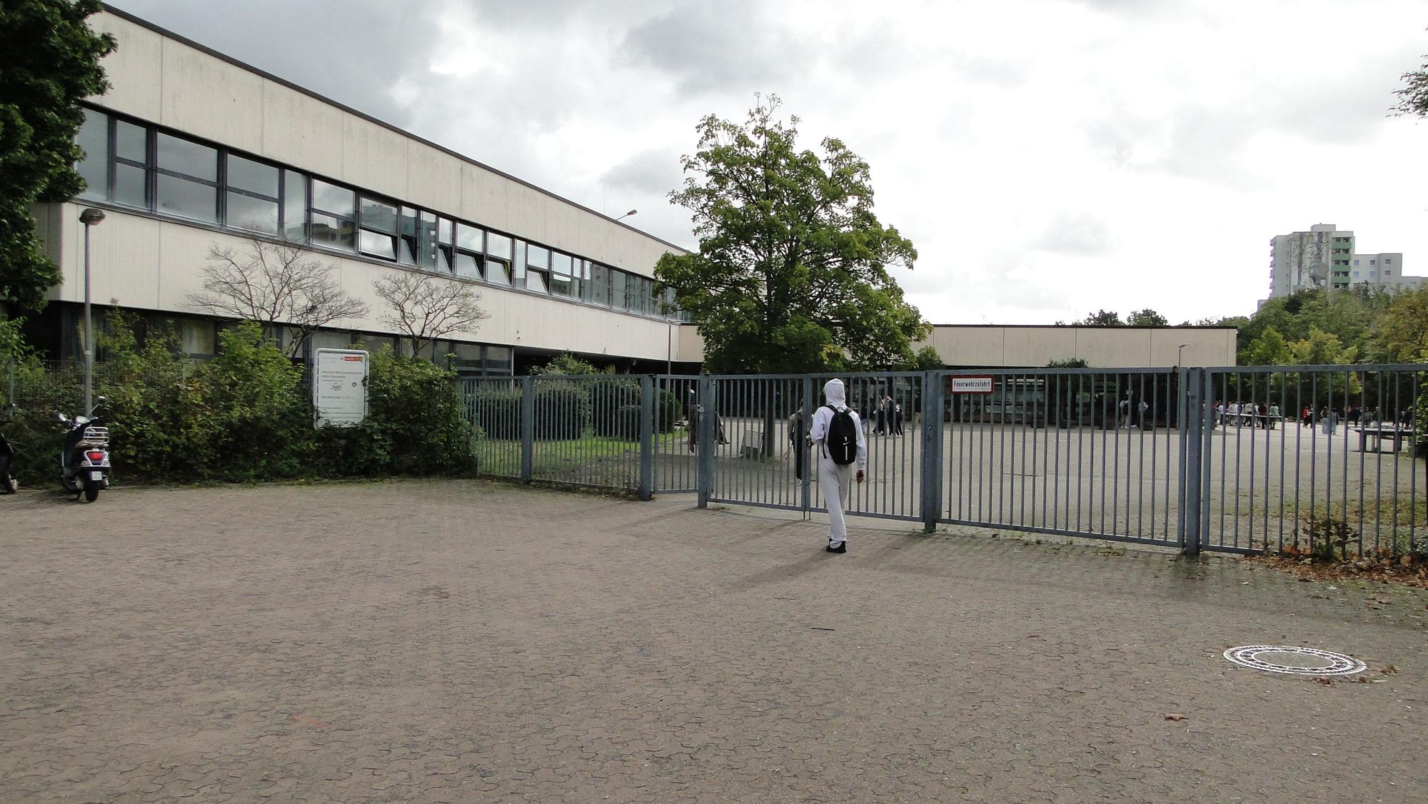 Eingang zum Schulhof und -Gebäude der Heinrich-Böll-Gesamtschule in Chorweiler.
